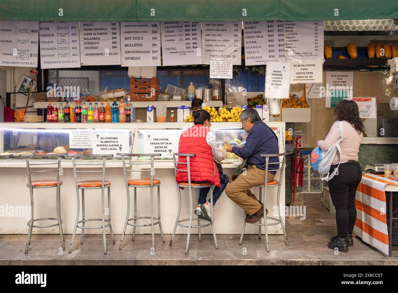 Essen in Mexiko-Stadt; Menschen, die Street Food in einem Straßencafé in Mexiko-Stadt essen; Mexiko-Stadt, Mexiko Stockfoto