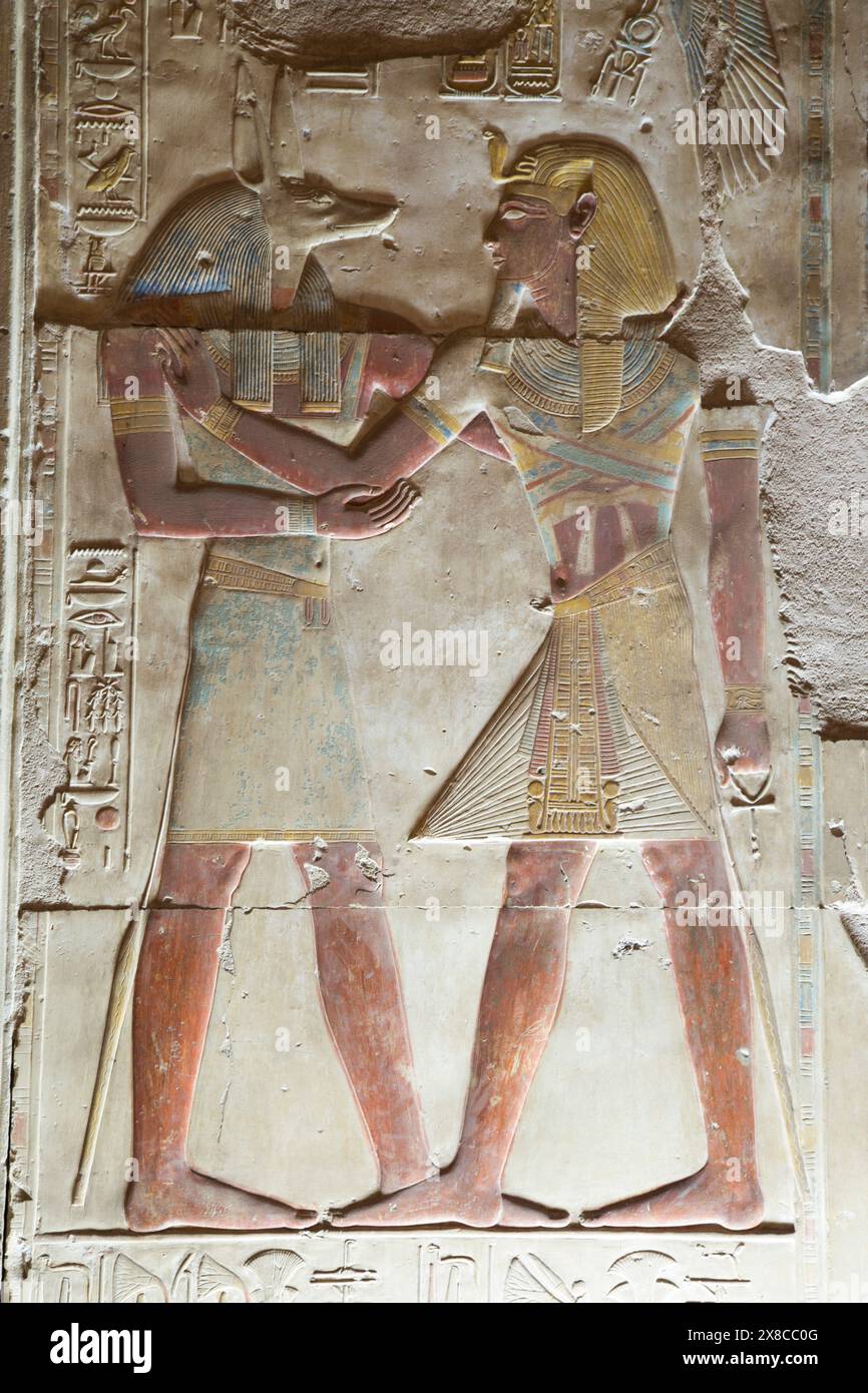 BAS-Relief des Gottes Anubis (links), Pharao Seti I. (rechts), Tempel von Seti I., Abydos, Ägypten Stockfoto