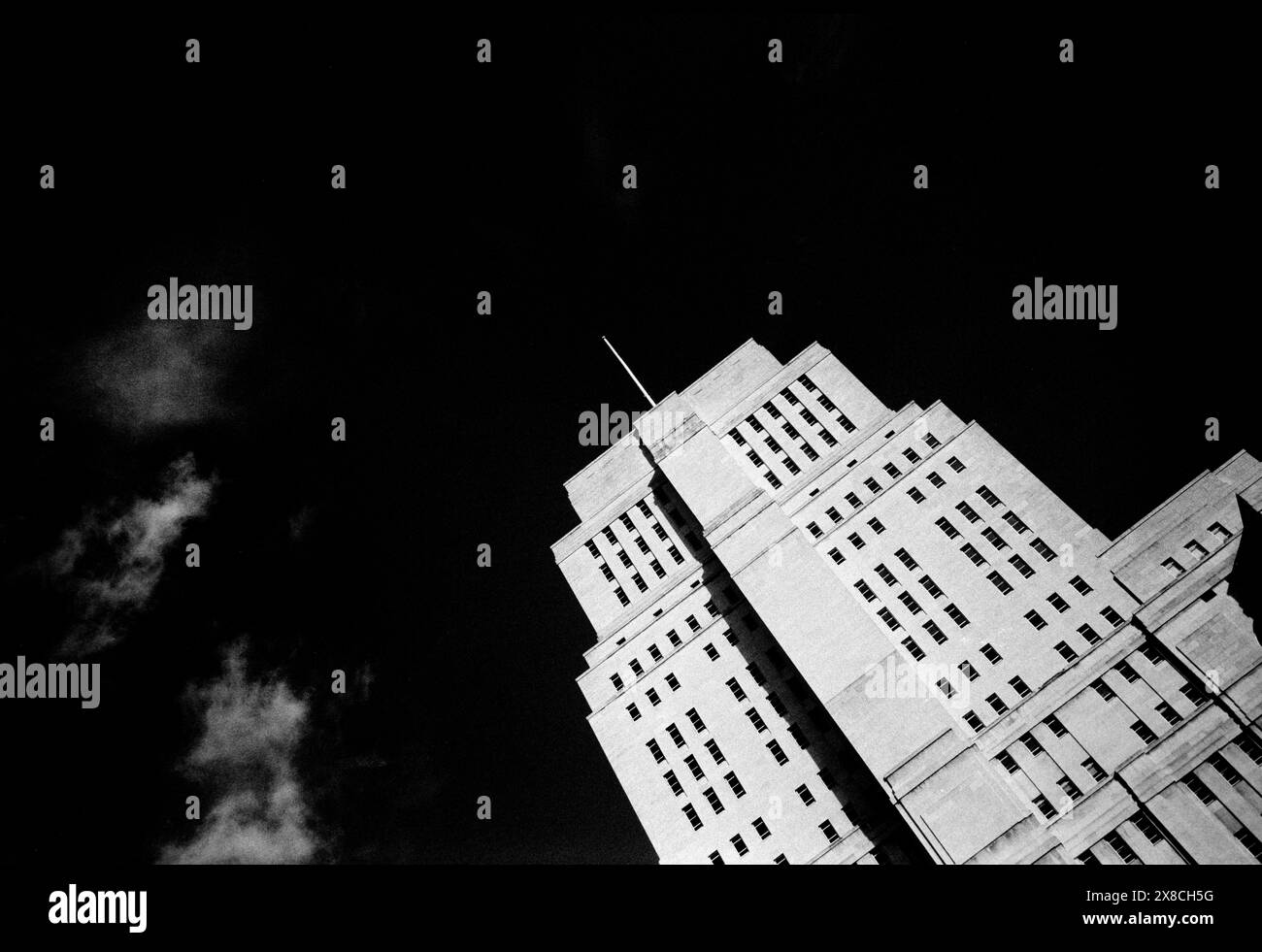 Senate House University of London, London England Senate House ist das Verwaltungszentrum der University of London im Herzen von Bloomsbury, London, direkt nördlich des British Museum. Das Art déco-Gebäude wurde zwischen 1932 und 1937 als erster Bauabschnitt eines großen, unvollendeten Bauprojekts errichtet, das Charles Holden für die Universität entwarf. Er besteht aus 19 Etagen und ist 210 Fuß (64 m) hoch. Während des Zweiten Weltkriegs inspirierte die Nutzung des Gebäudes durch das Informationsministerium zwei Werke englischer Schriftsteller. Der erste, Graham Greenes Roman der Mini Stockfoto