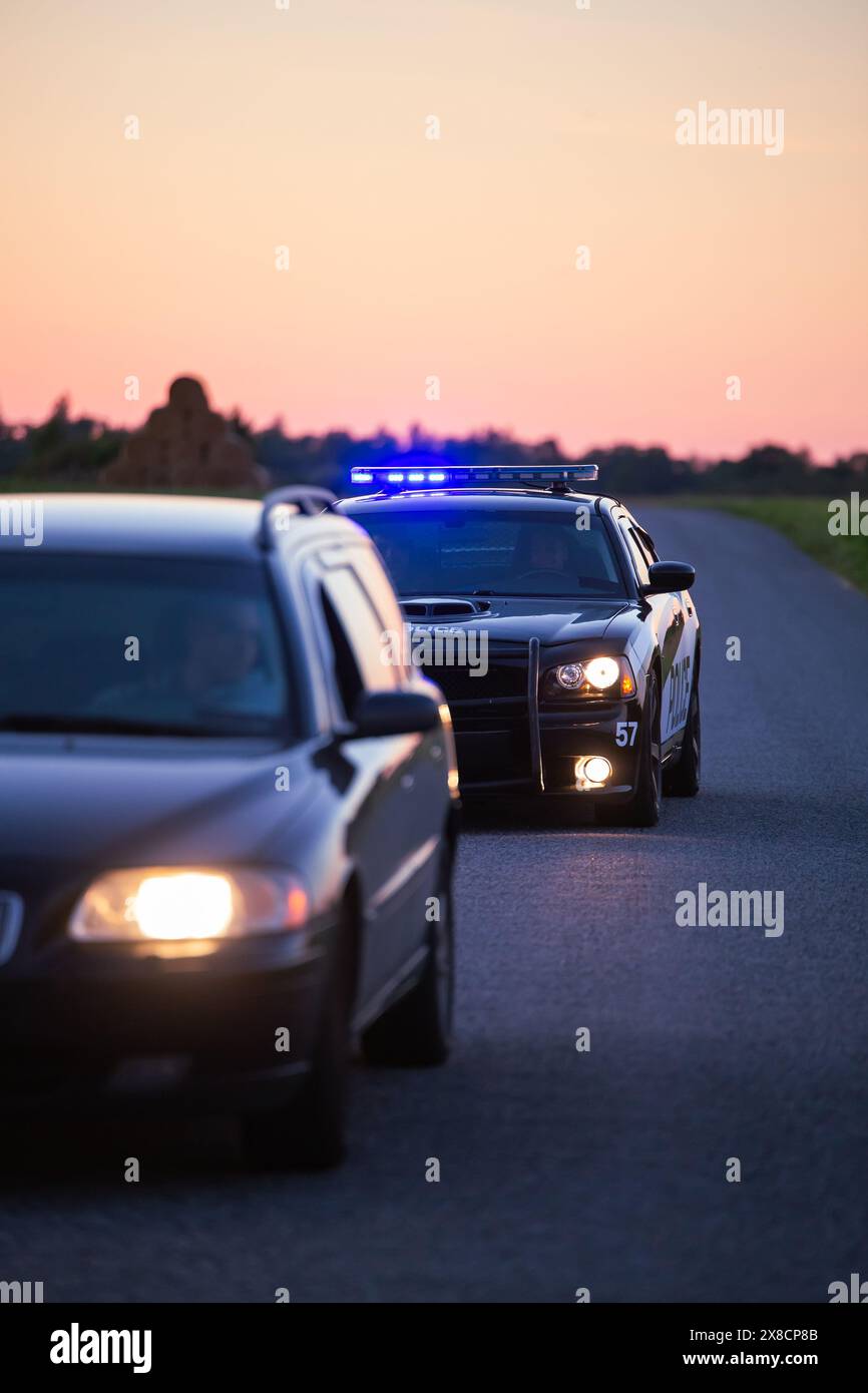 Highway Traffic Patrol Auto Verfolgung Kriminelle im Fahrzeug. Polizisten jagen Verdächtigen auf der Straße, Sirenen zünden, Dust Fying. Stilvolle Action-Szene in Kinoqualität Stockfoto