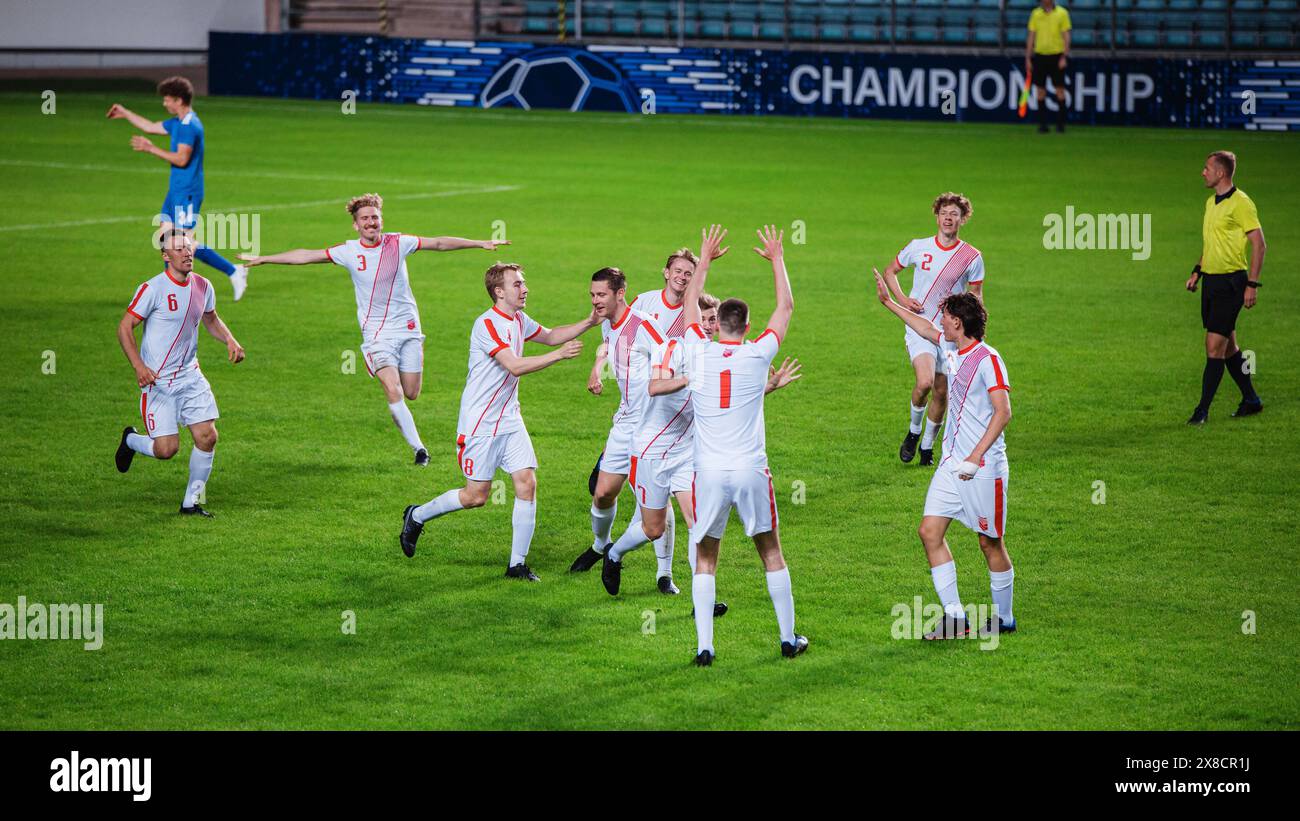 Fußball-Meisterschaft Endspiel: Die Spieler des weißen Teams freuen sich und feiern den Sieg, umarmen sich nach dem Sieg des Major League Sport Events. Tv-Senderkonzept. Stockfoto