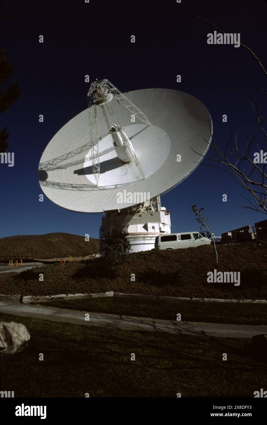 Fort Irwin, CA., USA, ca. 1984. Der Goldstone Deep Space Communications Complex (GDSCC), gemeinhin Goldstone Observatory genannt, befindet sich in Fort Irwin im US-Bundesstaat Kalifornien. Betrieben vom Jet Propulsion Laboratory (JPL) der NASA, um interplanetare Weltraummissionen zu verfolgen und mit ihnen zu kommunizieren. Benannt ist sie nach Goldstone, Kalifornien, einer nahe gelegenen Geisterstadt im Goldbergbau. Die größte, eine 70 Meter (230 ft) große Cassegrain-Antenne, wird für die Kommunikation mit Weltraummissionen zu den äußeren Planeten, wie der Voyager-Raumsonde, verwendet. Stockfoto