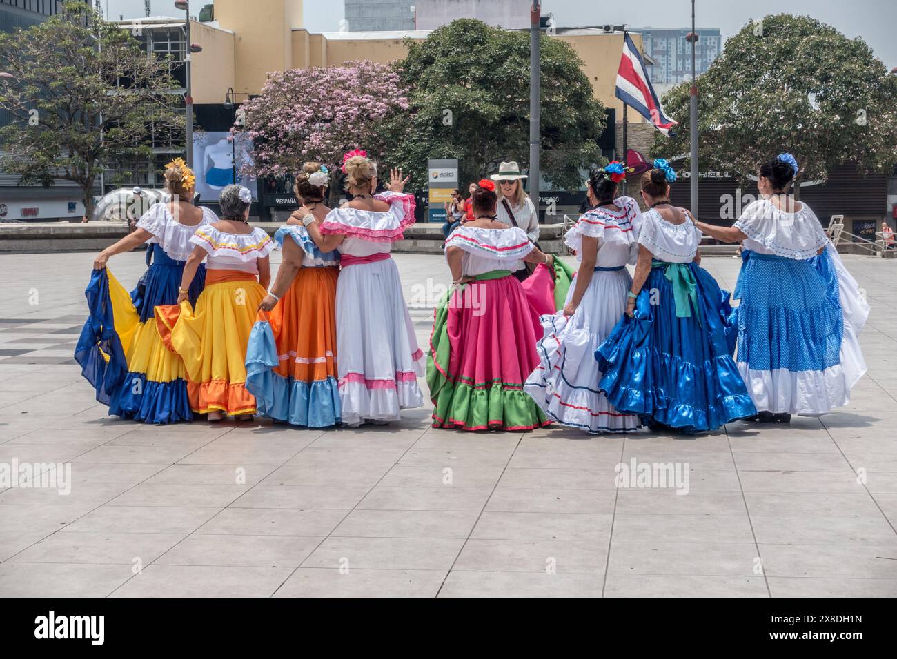 Ältere Frauen in traditionellen Costa-ricanischen Kleidern mit dem Rücken sprechen mit einer Frau in San José, Costa Rica. Stockfoto