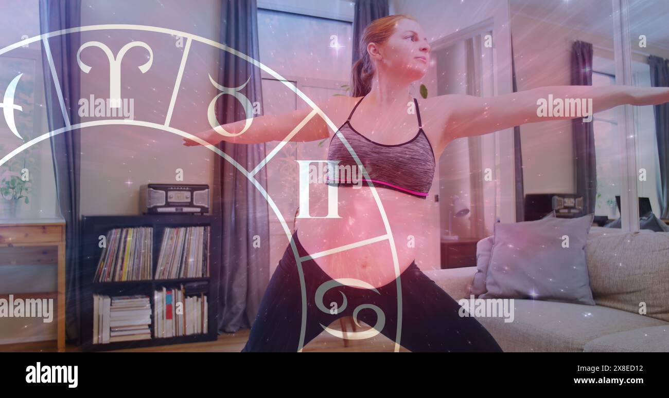 Eine junge kaukasische Frau, die Sportkleidung trägt und zu Hause Yoga praktiziert Stockfoto