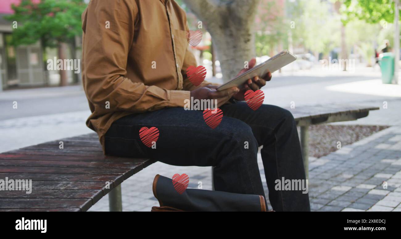 Afroamerikaner auf der Bank, braune Jacke, rotes Buch in der Hand Stockfoto