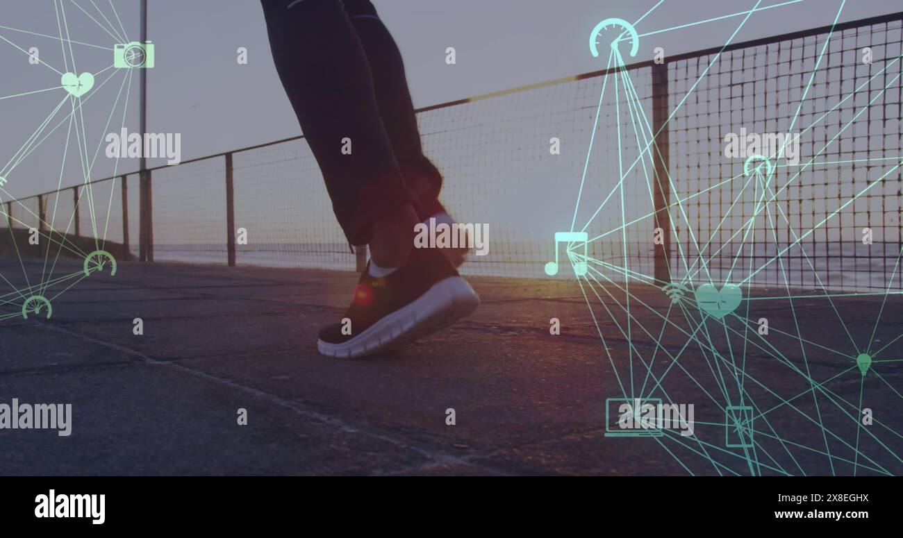 Bild der verbundenen Icons Globen über dem unteren Teil der Person, die am Strand läuft Stockfoto