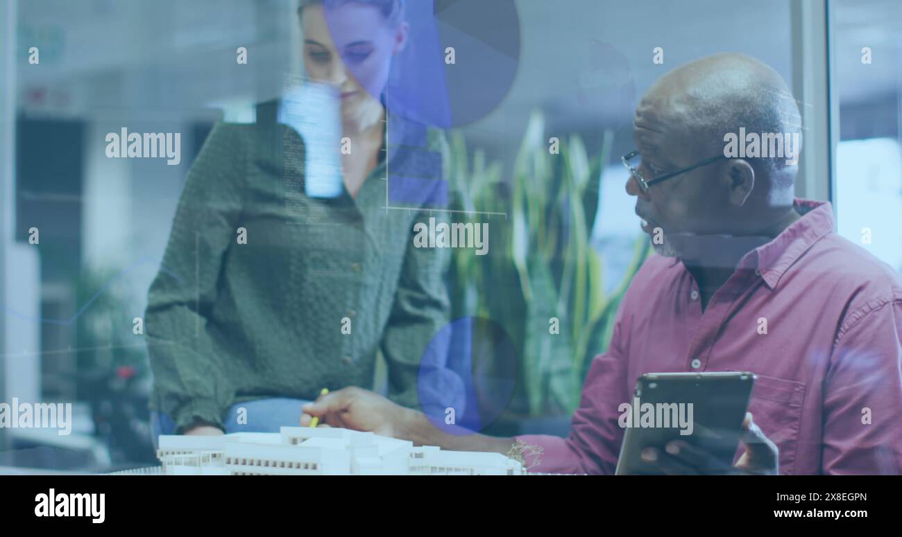 Bild von mehreren Diagrammen und Computersprache, verschiedene Kollegen diskutieren am Schreibtisch Stockfoto