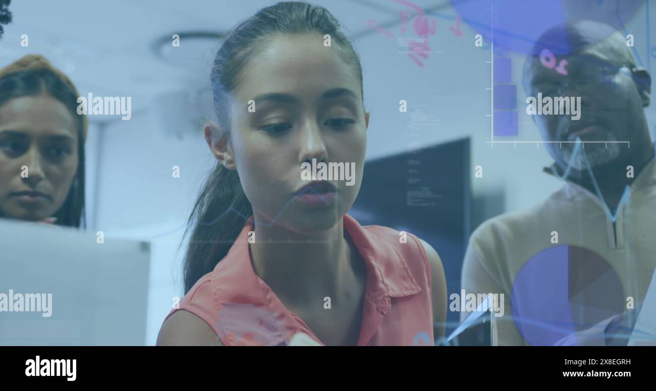 Verschiedene Kollegen arbeiten im Büro zusammen und schauen sich den Computerbildschirm an Stockfoto