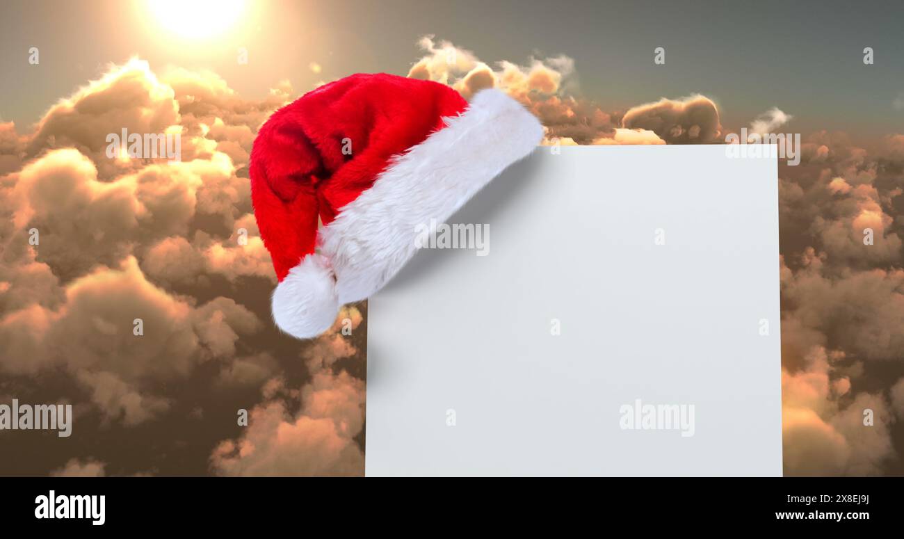 Digital Composite aus Weihnachtsmann Hut mit weißer Karte und Wolken Stockfoto