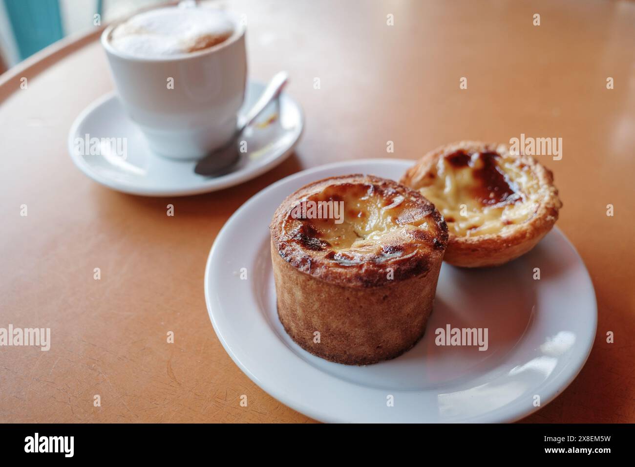 Nahaufnahme zweier portugiesischer Pudding-Torten, auch bekannt als Pastéis de Nata, serviert auf einem weißen Teller. Stockfoto