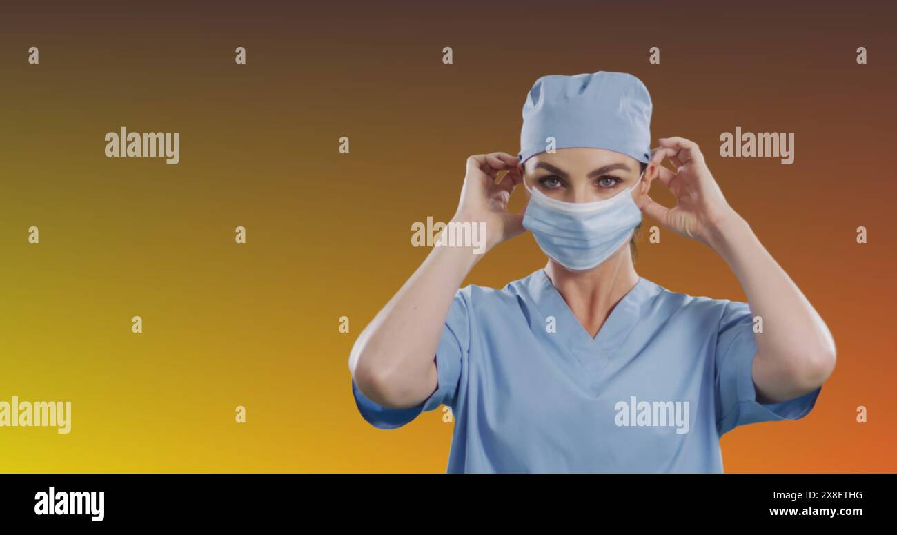 Kaukasische Krankenschwester trägt blaue Peelings und passt ihre Maske an Stockfoto