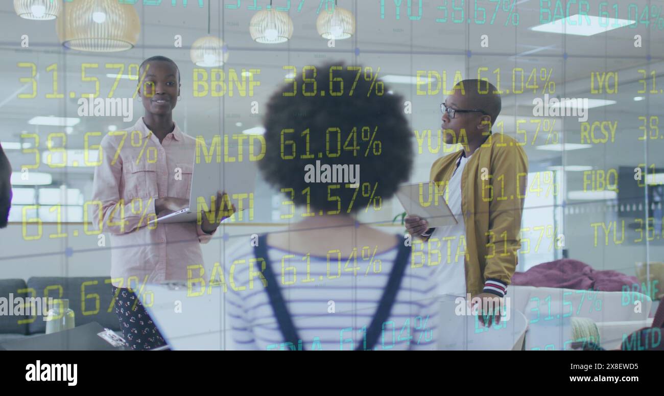 Bild der Verarbeitung von Börsendaten über verschiedene Kollegen, die gemeinsam im Büro diskutieren Stockfoto