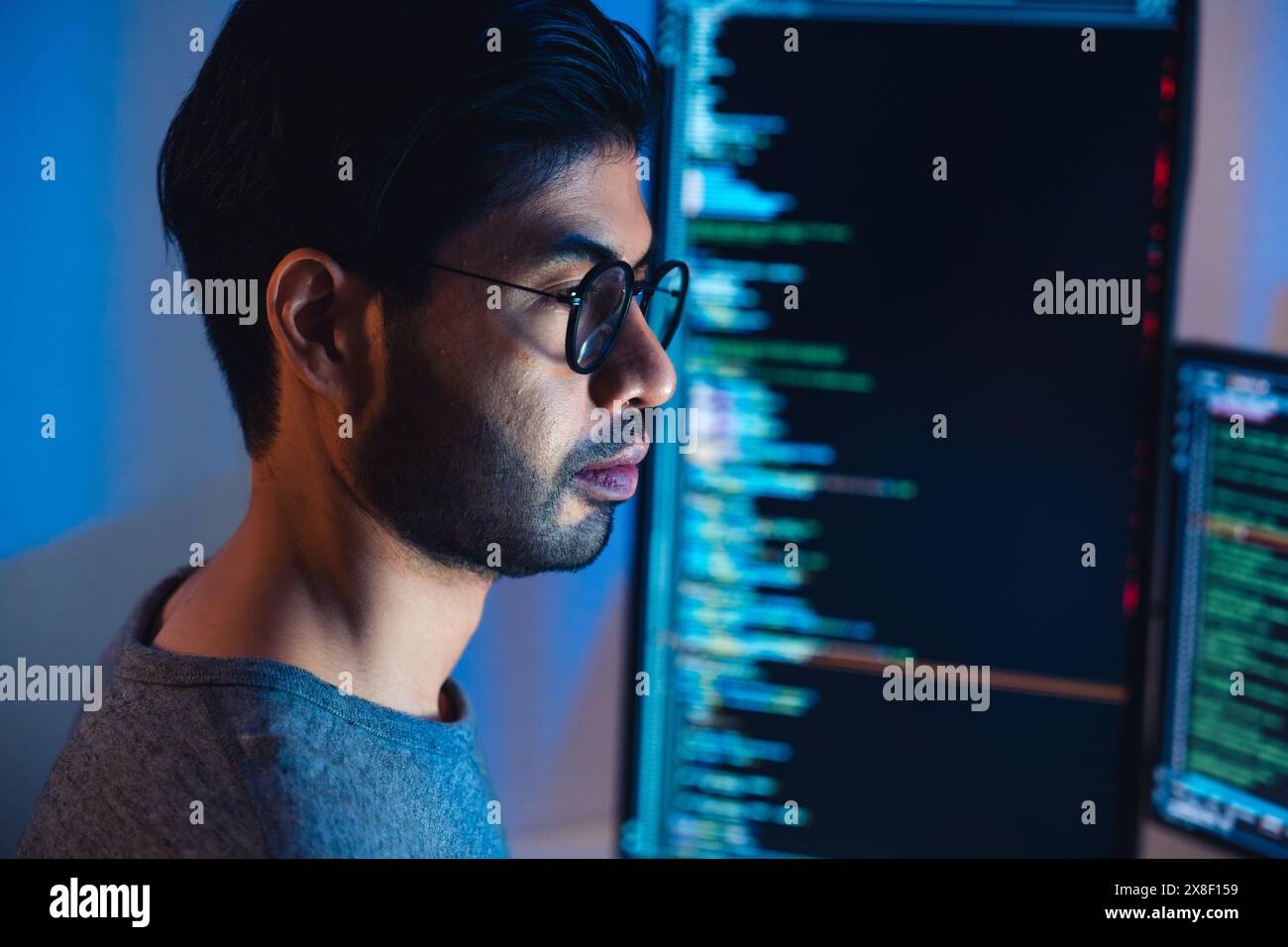 Indische Software-Entwicklung arbeitet an der Kodierung von Computerbildschirm und Flussdiagramm in der Nacht in modernen Büros Stockfoto