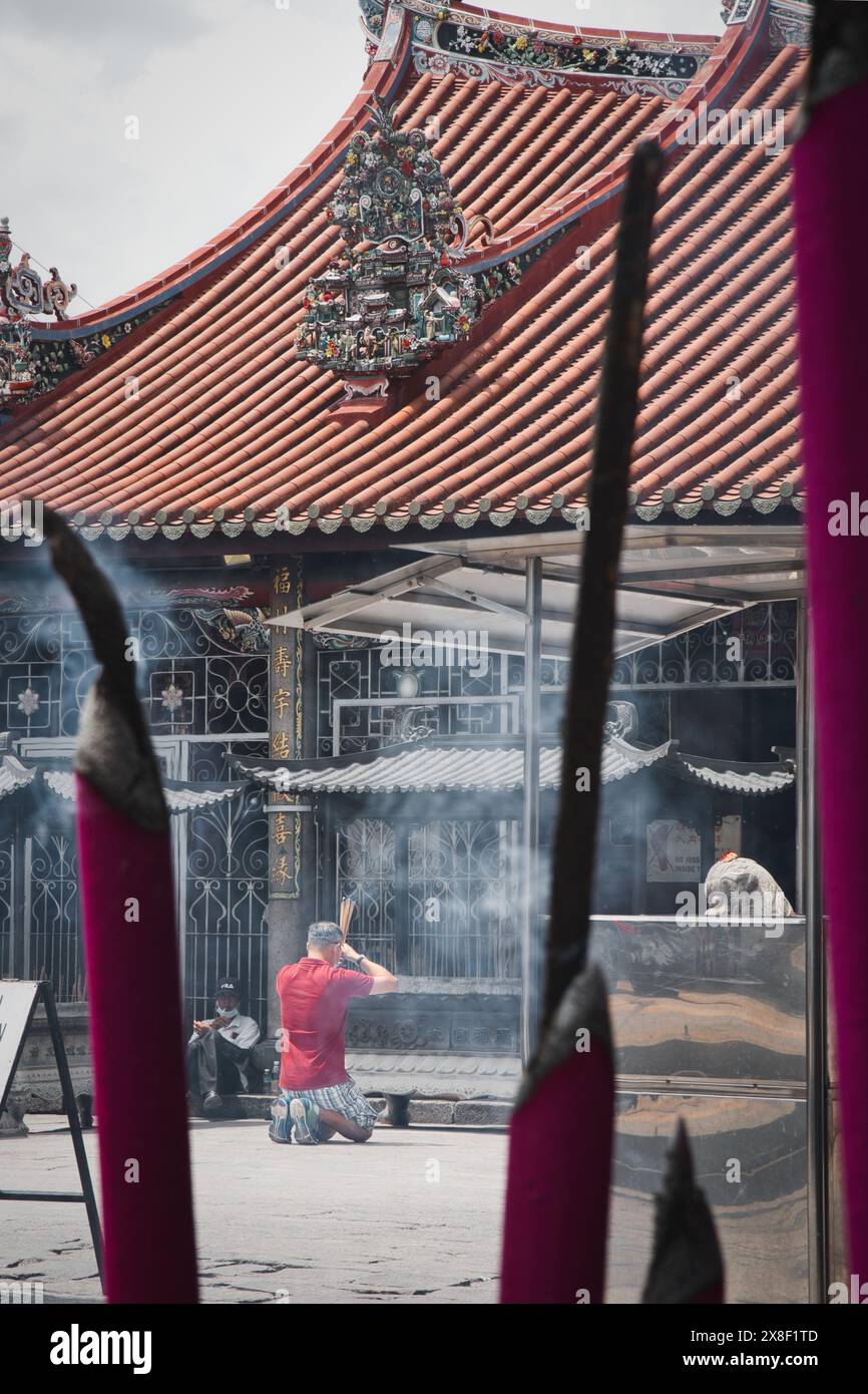 Penang, Malaysia – 1. November 2022: Mann kniet und betet mit Joss-Stöcken im Tempel der Göttin der Mercy in der Pitt Street, bekannt als Kuan im Teng. Stockfoto