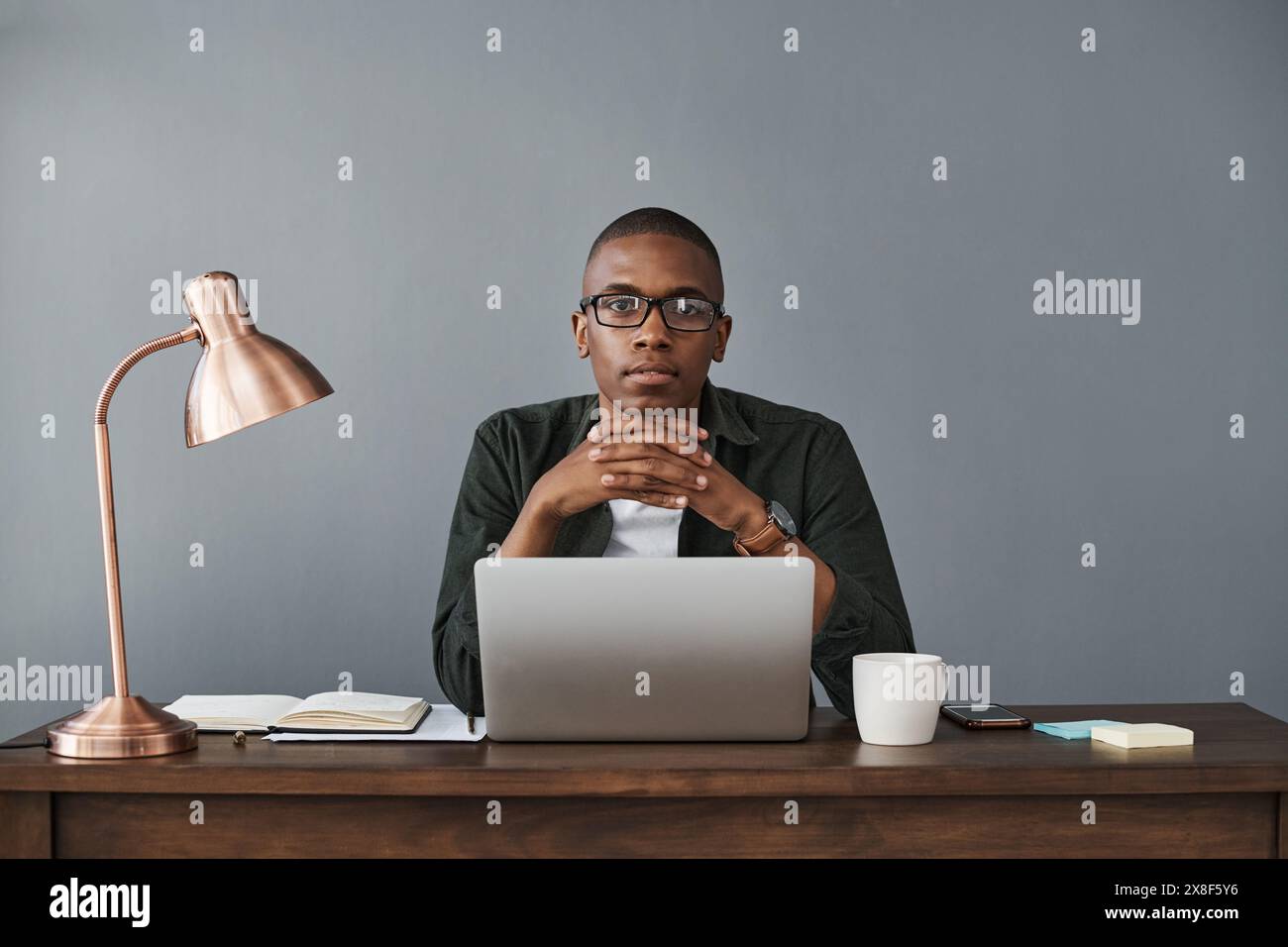 Selbstbewusster Schwarzer, Laptop und Porträt im Büro für Software, Online-Forschung und kreatives Startup-Unternehmen. Gesicht, Computer und Internet Stockfoto
