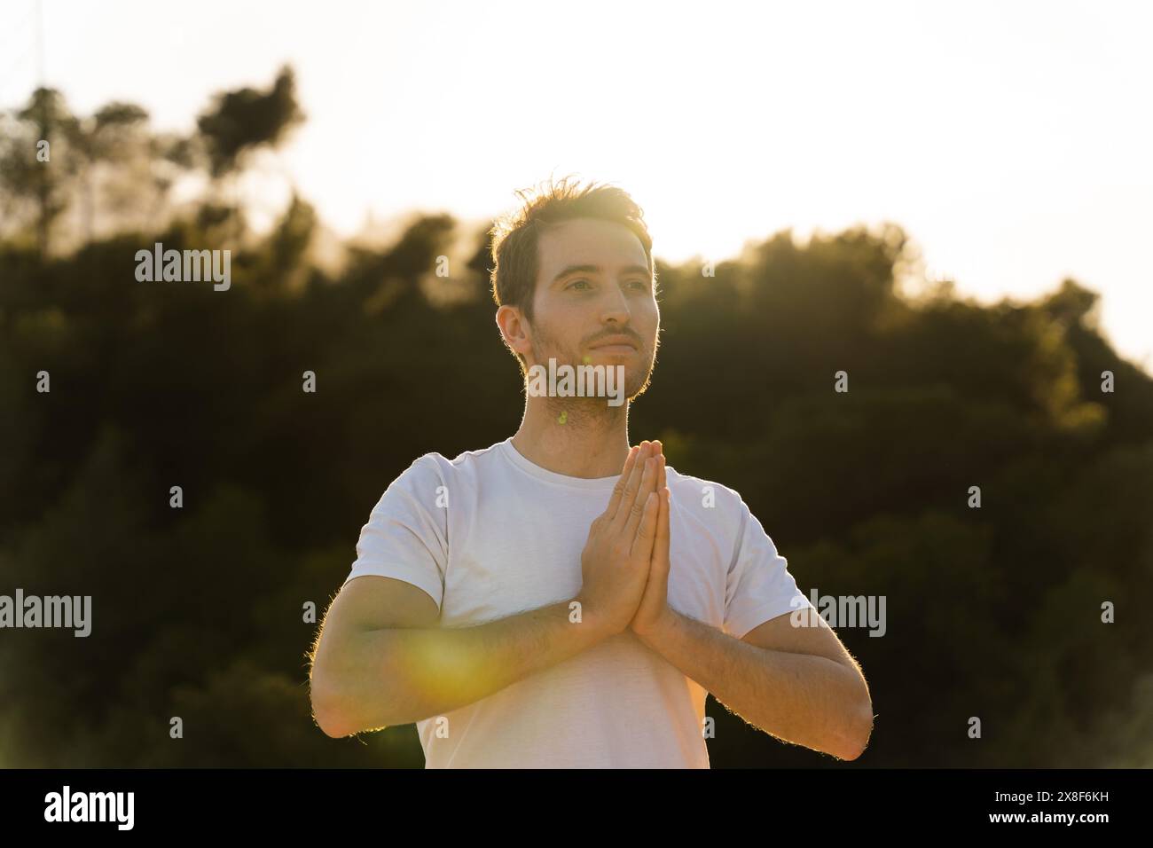 Ein Mann praktiziert Yoga in der Natur bei Sonnenuntergang Stockfoto