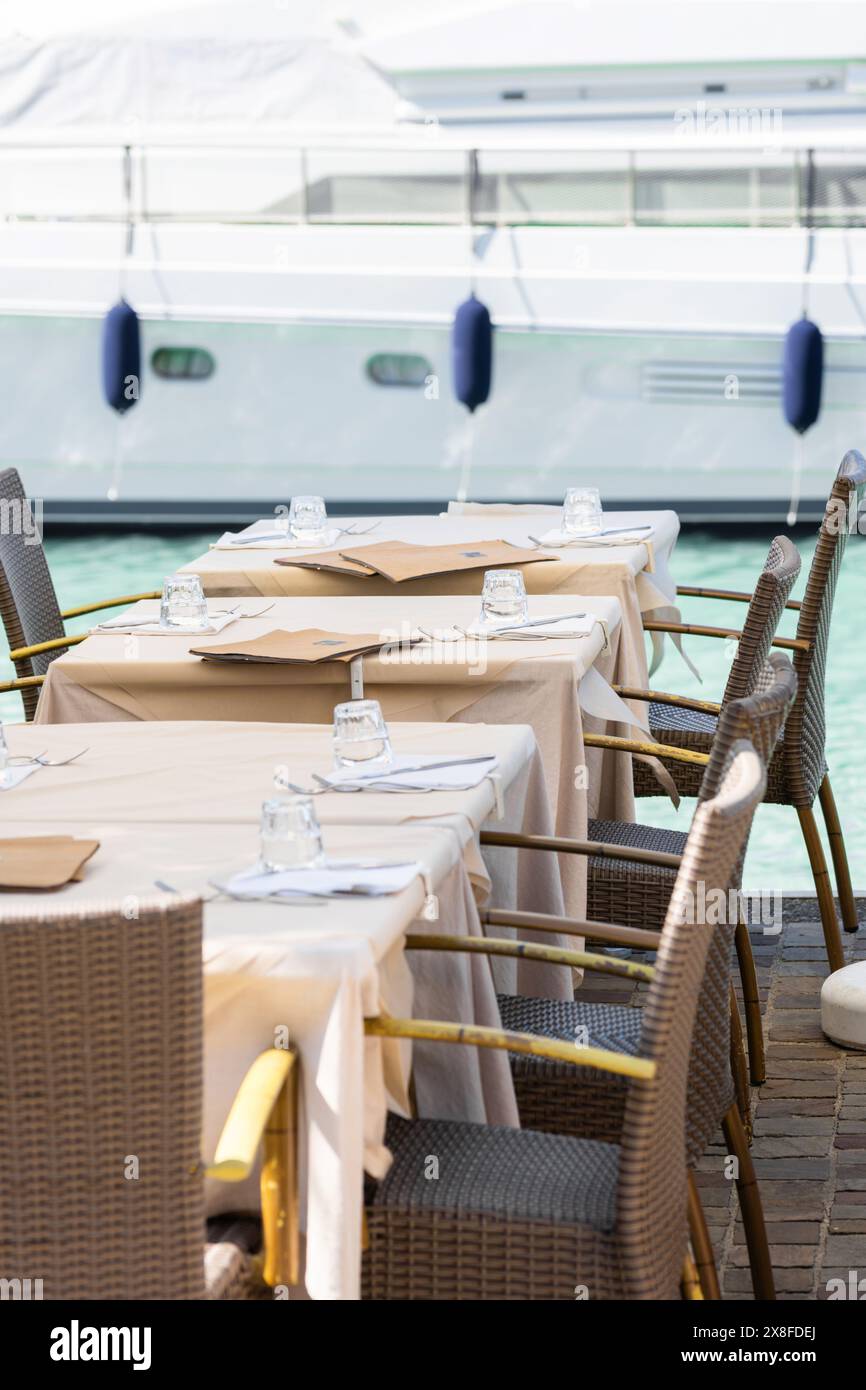 Esstische im Freien am Yachthafen mit Yachten Stockfoto