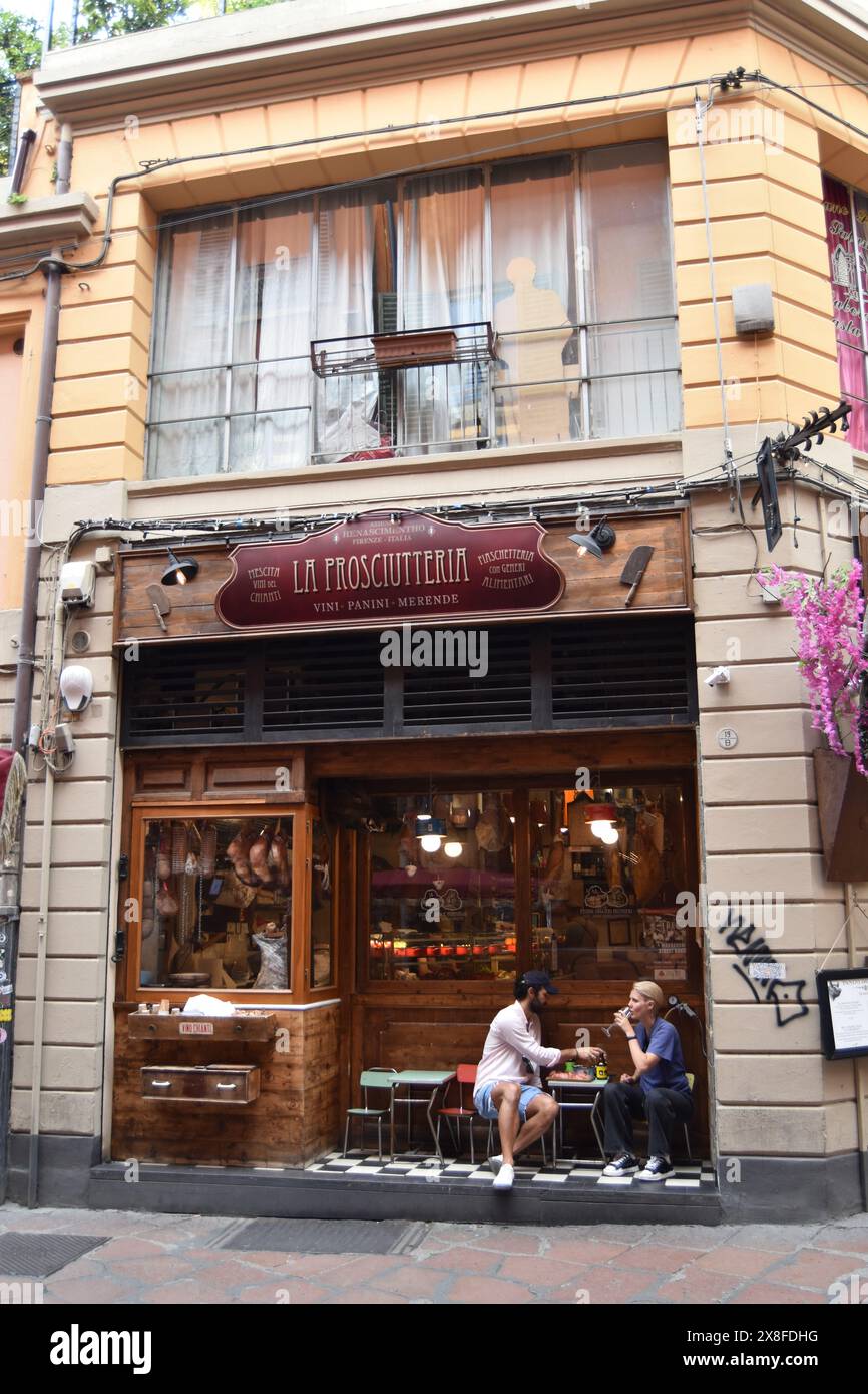 Ein Paar genießt an einem Tag im Mai auf der Via Oberdan in Bologna, Italien, einige handwerkliche Speisen und Getränke. Stockfoto