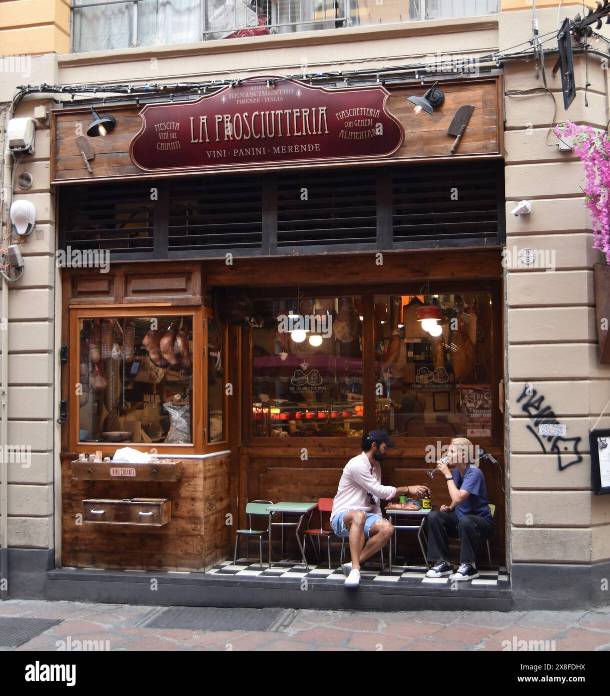 Ein Paar genießt an einem Tag im Mai auf der Via Oberdan in Bologna, Italien, einige handwerkliche Speisen und Getränke. Stockfoto