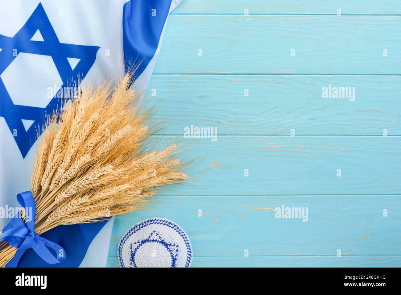 Shavuot jüdischer Hintergrund. Reifer Weizenstrauß mit blauem Band mit Israel-Flagge und Hintergründen. Symbole des jüdischen Feiertags Shavuot-Konzepts. Backgro Stockfoto