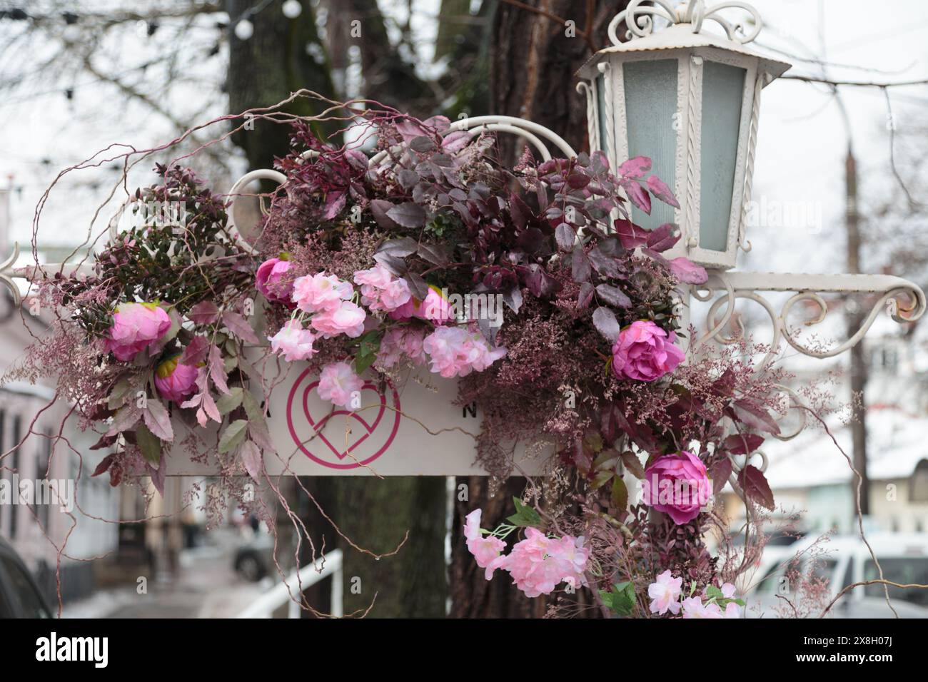 Die Stadtstraße ist mit künstlichen Blumen dekoriert. Eine erstaunliche Kombination aus weiß und Rosa in der Architektur der Stadt. Stockfoto Die Stadtstraße ist mit künstlichen Blumen dekoriert. Eine erstaunliche Kombination aus weiß und Rosa in der Architektur der Stadt. Stockfoto