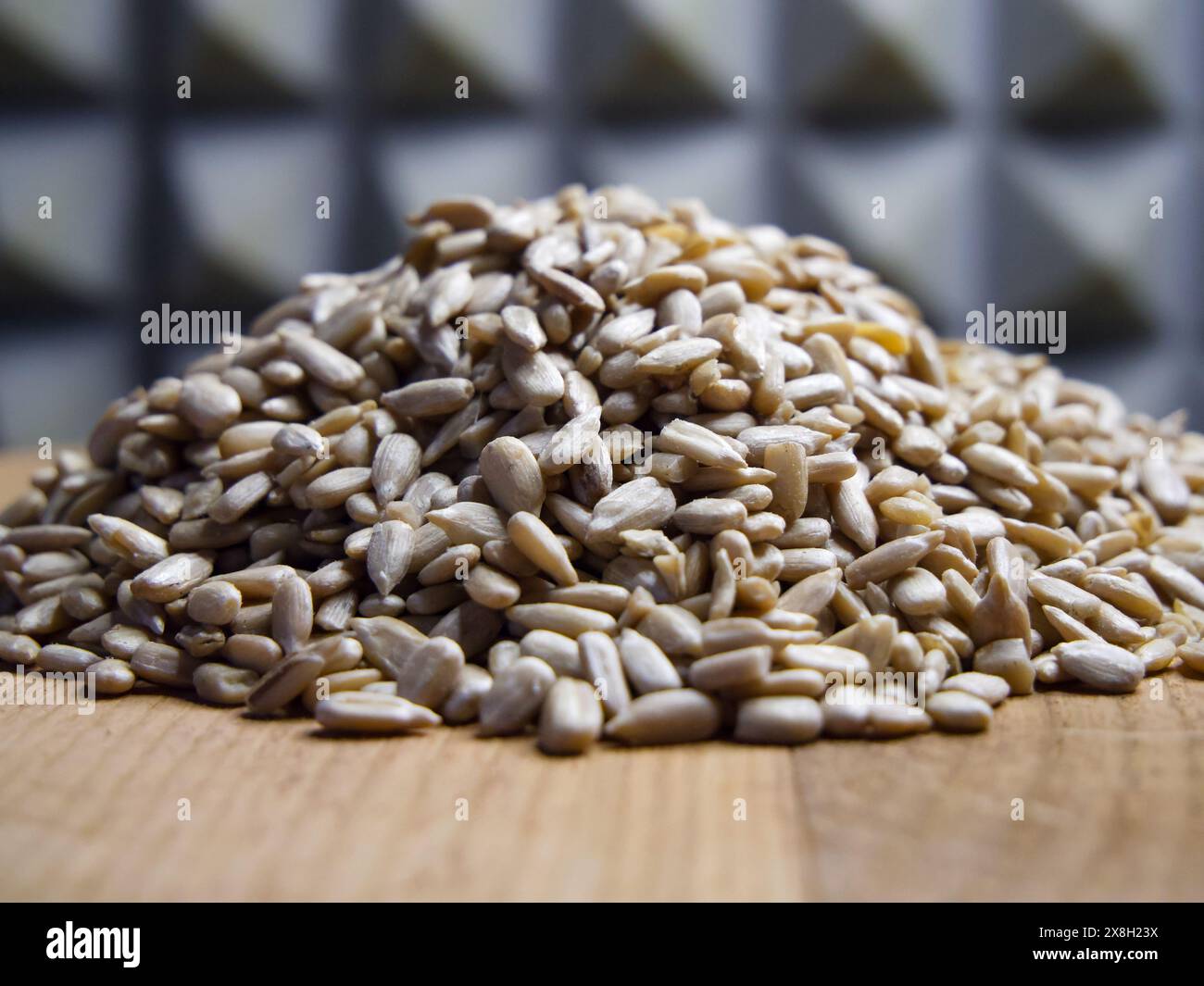 Sonnenblumenkerne Nahaufnahme. Nahaufnahme von Sonnenblumenkernen auf Holz, geeignet für kulinarische Kunst oder Nährwertangaben. Stockfoto