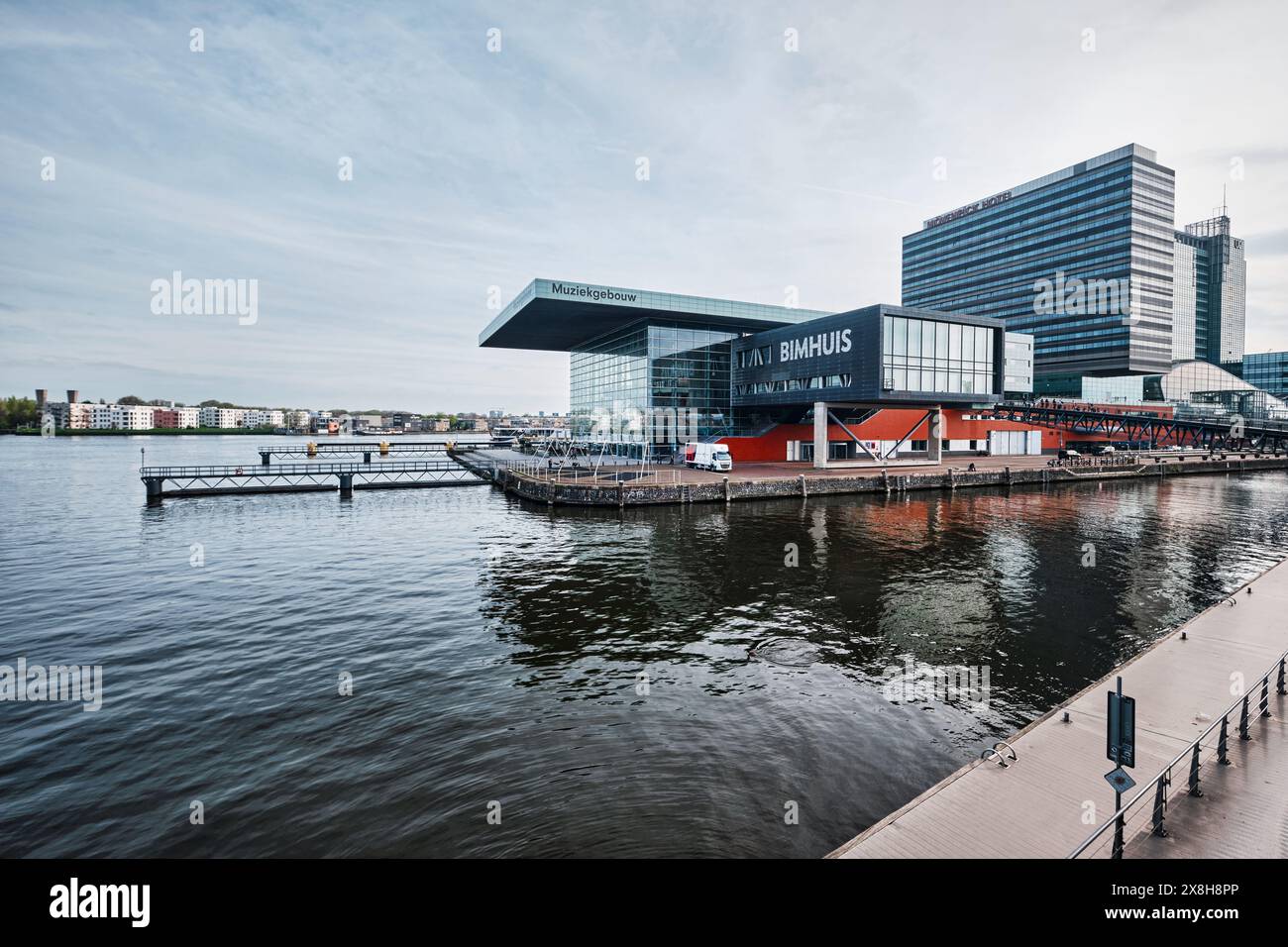Niederlande, Amsterdam - 08. April 2024: Modernes kubisches Gebäude mit Musiktheater und Schule mit Jazz Bimhuis auf der Plattform im Fluss IJ Stockfoto