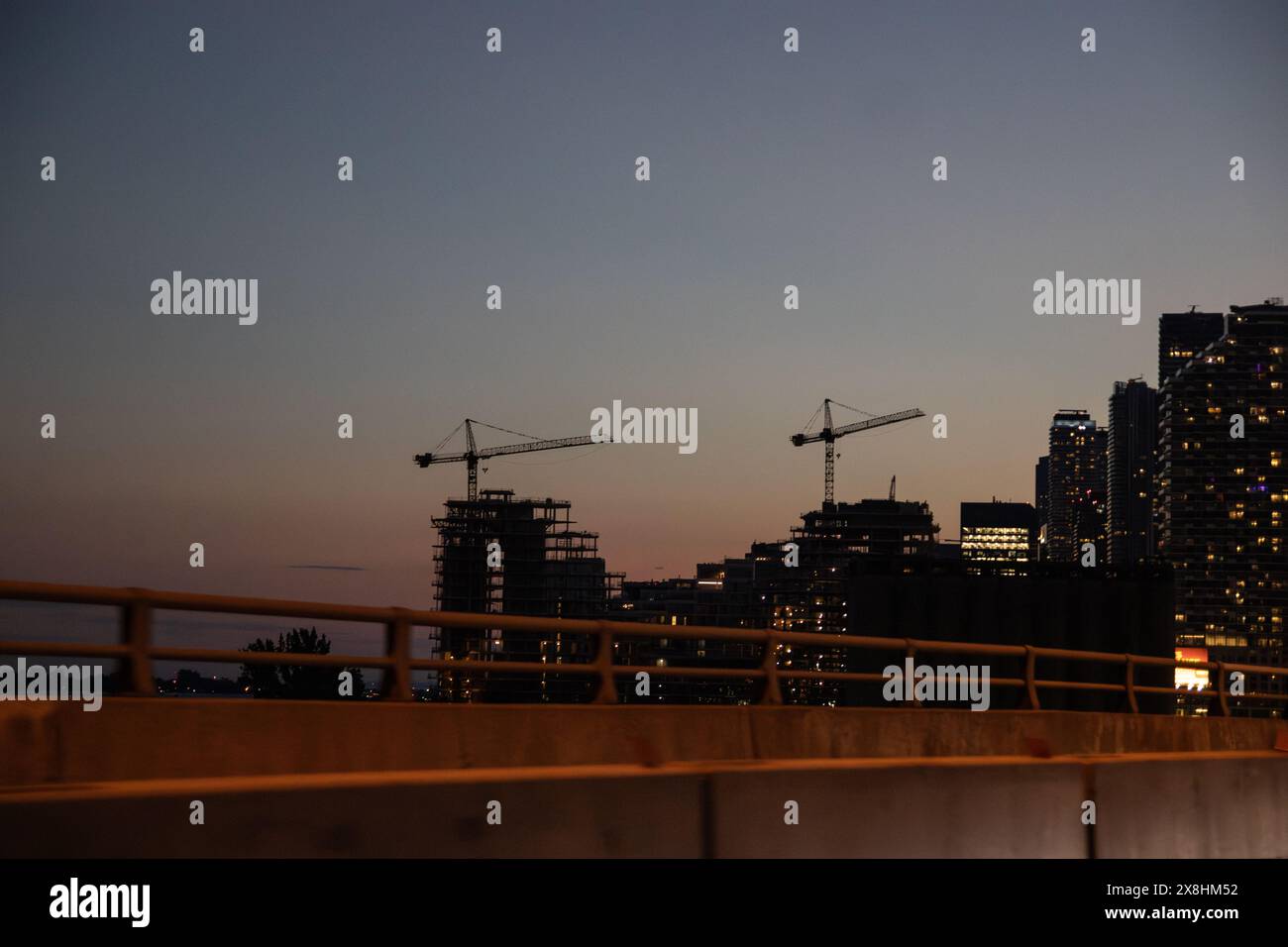 Skyline am Abend - Baukräne Silhouette gegen verblassendes Licht - Stadtentwicklung. Aufgenommen in Toronto, Kanada. Stockfoto