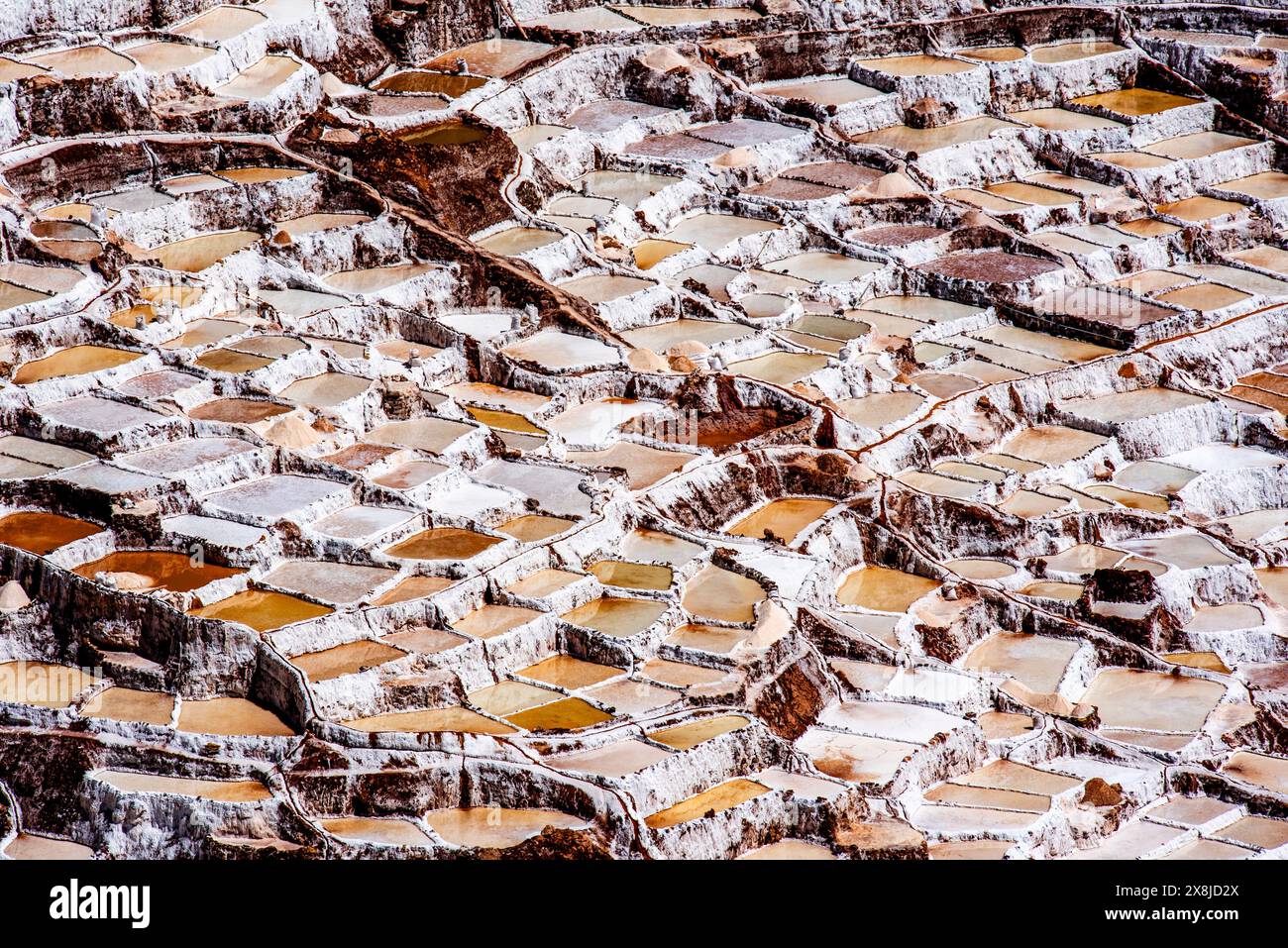 Detail der Bergsalzpfannen mit dem weiß des Salzes und dem Braun des Wassers, das sich in Peru mit Verdunstung in Salz verwandelt Stockfoto
