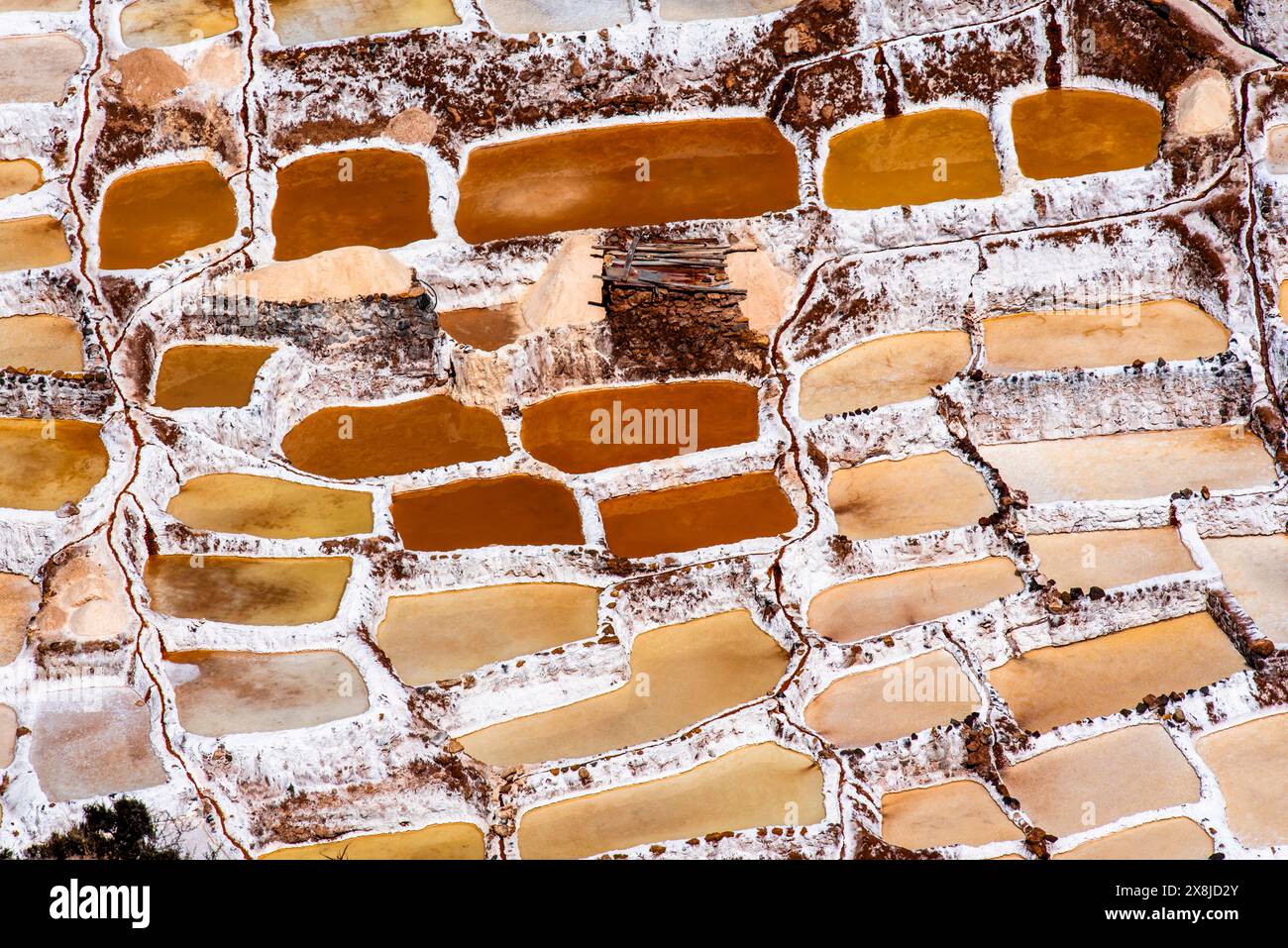 Detail der Bergsalzpfannen mit dem weiß des Salzes und dem Braun des Wassers, das sich in Peru mit Verdunstung in Salz verwandelt Stockfoto