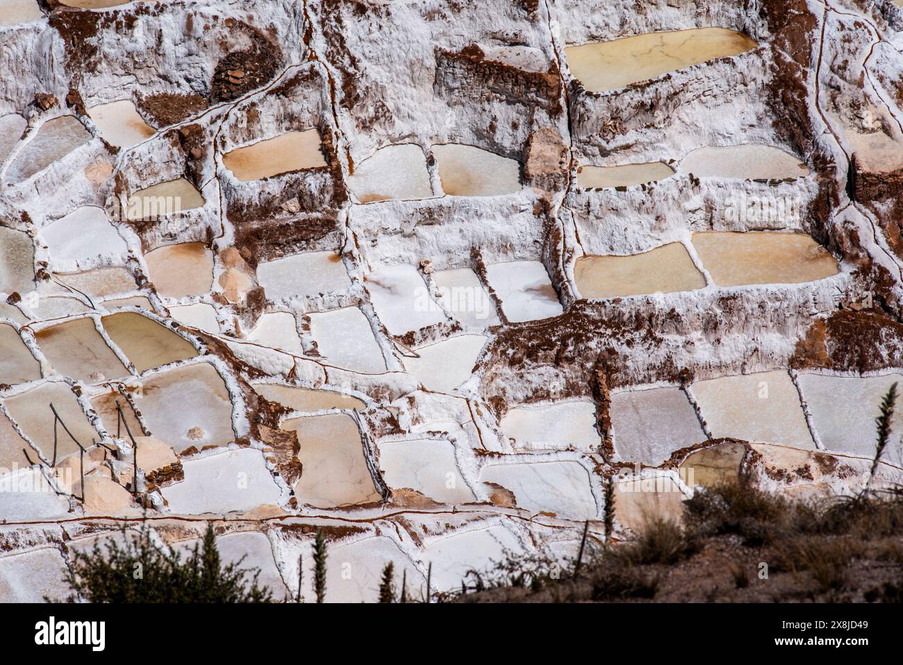 Detail der Bergsalzpfannen mit dem weiß des Salzes und dem Braun des Wassers, das sich in Peru mit Verdunstung in Salz verwandelt Stockfoto