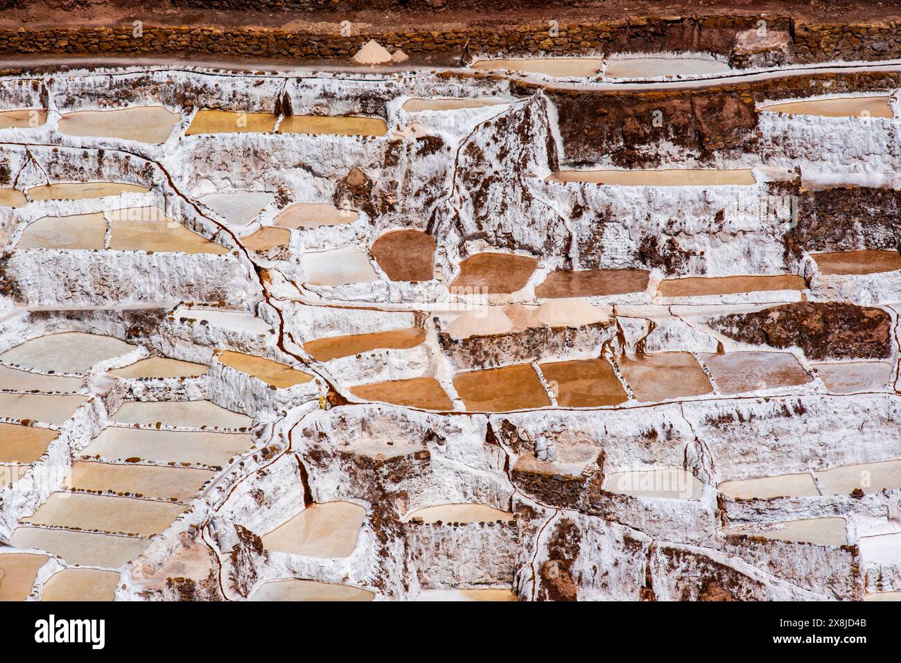 Detail der Bergsalzpfannen mit dem weiß des Salzes und dem Braun des Wassers, das sich in Peru mit Verdunstung in Salz verwandelt Stockfoto