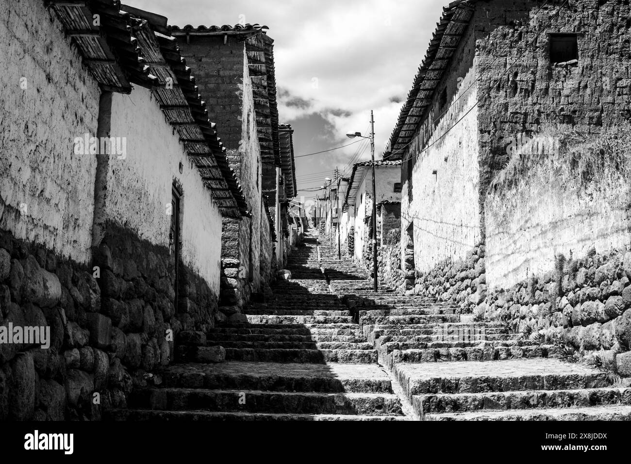 Detail eines kleinen Dorfes in den Bergen der Anden mit braunen Steinstraßen, weißen Häusern und Plätzen mit dem Markt in Peru in Südamerika Stockfoto