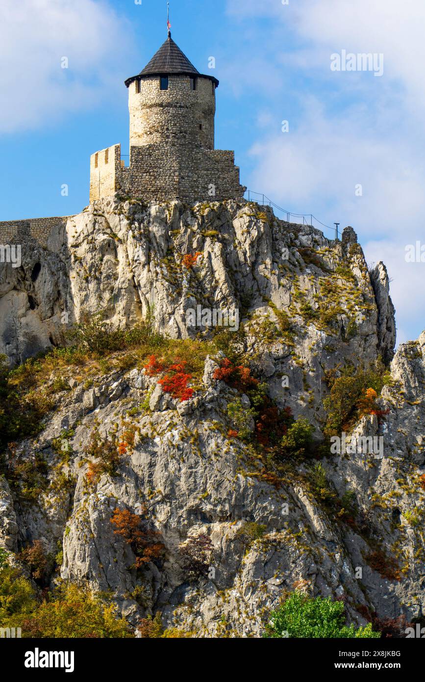 Atemberaubende mittelalterliche Festung hoch oben auf felsigen Klippen mit klarem blauem Himmel und lebhaftem Herbstlaub, die die ruhige Kulisse des Donauflusses bereichern Stockfoto