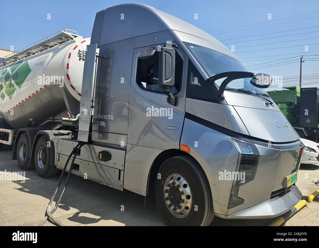 Ein schlanker, moderner Elektrofahrzeug parkt an einer Ladeinfrastruktur. Die helle Mittagssonne unterstreicht die Metallic-Oberfläche des Lkws, während er für die nächste Aufgabe bereit ist. / Binzhou Shandong China Stockfoto