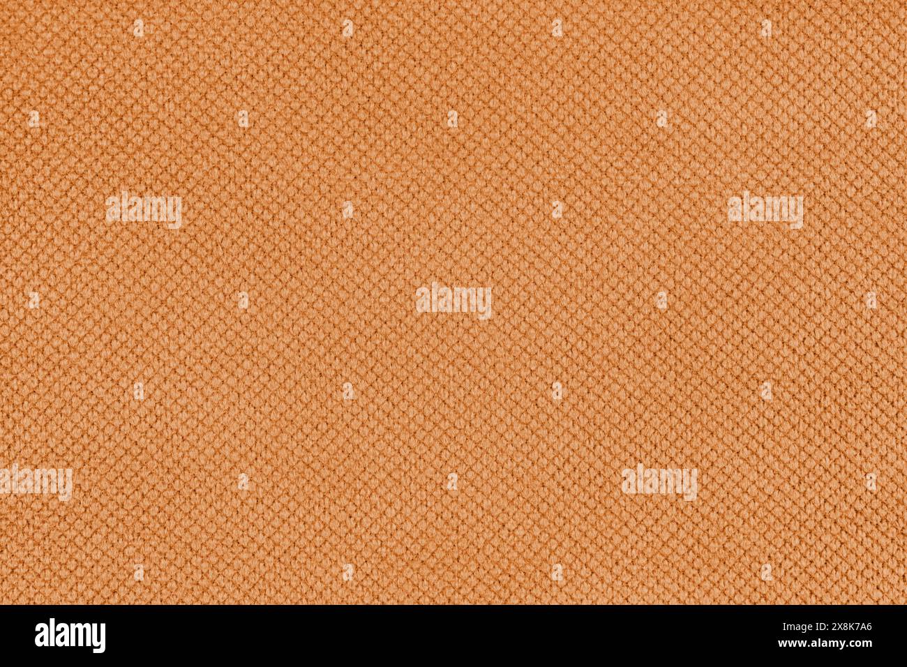 Einfarbiger orangefarbener Veloursstoff, Jacquard mit feinem Hintergrund mit Rautenstruktur. Nahaufnahme, Textiloberfläche aus Makrogewebe. Tapete, Hintergrund mit C Stockfoto