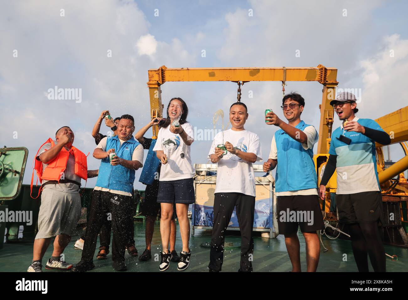 (240526) -- SANYA, 26. Mai 2024 (Xinhua) -- Mitarbeiter feiern, nachdem sie den Kurzflossen-Pilotwal „Haitang“ auf einem Forschungsschiff ins Meer gebracht haben, 26. Mai 2024. Am 3. Januar dieses Jahres wurde ein verletzter männlicher Kurzflossen-Grindwal in der Haitang Bay von Sanya gefunden. Es wurde zur Behandlung an das Sanya Haichang Animal Conservation Center geschickt und erhielt den Namen „Haitang“. Dank der akribischen Betreuung durch professionelle Züchter und Freiwillige erholt sich „Haitang“ gut und ist entschlossen, nach gründlicher Untersuchung und Bewertung wieder ins Meer zurückgelassen zu werden Stockfoto