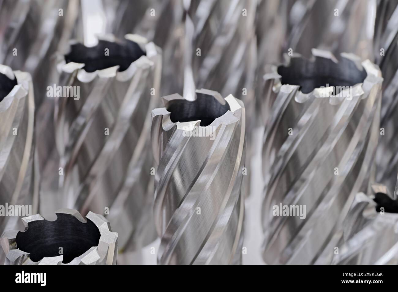 Große Gruppe von verschiedenen Kernschneidern, rotierenden Werkzeugen für die Metallbearbeitung. Nahaufnahme, selektiver Fokus. Abstrakter industrieller Hintergrund. Stockfoto
