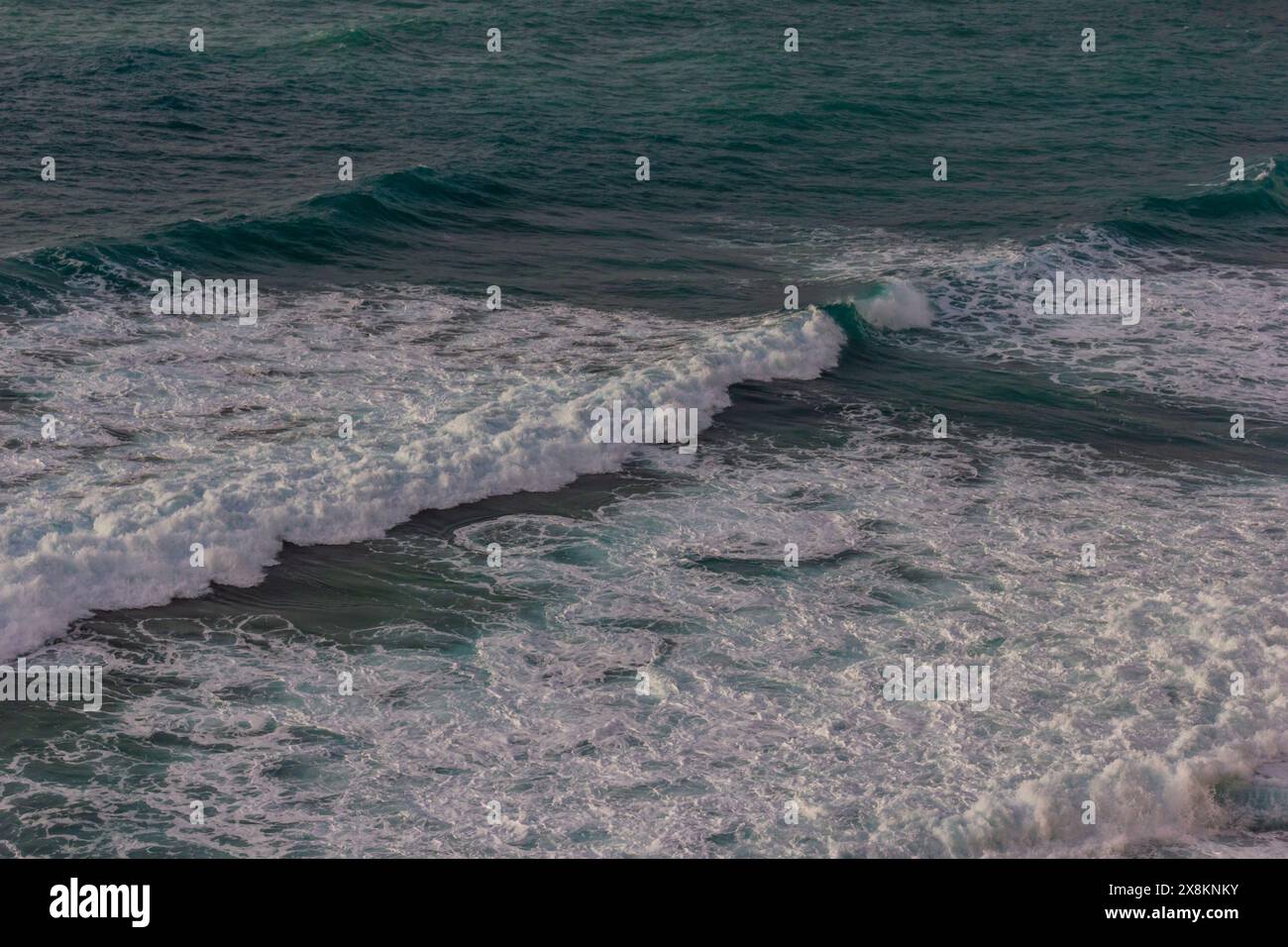 Eine atemberaubende blaue Meereslandschaft mit den Küsten- und Meereswellen in ständiger Bewegung, eine schöne Erinnerung an die Schönheit der Natur. Stockfoto