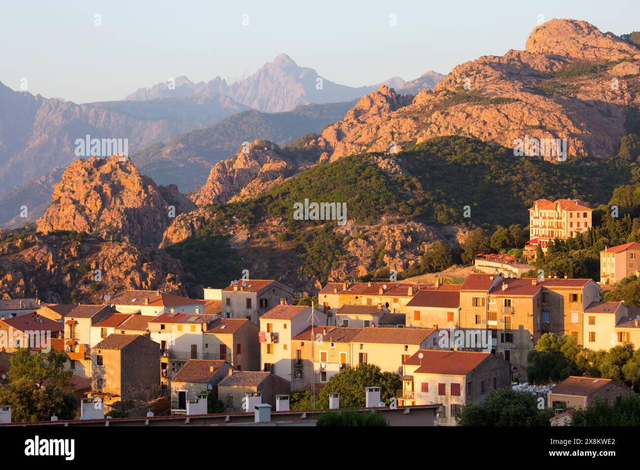 Piana, Corse-du-Sud, Korsika, Frankreich. Blick über die Skyline des Dorfes auf die hohe felsige Landschaft der Calanques, Sonnenuntergang. Stockfoto
