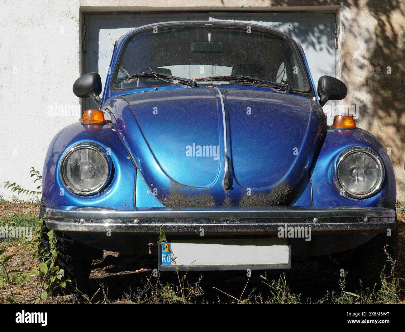 Bukarest, Rumänien - 2. Oktober 2022: Blauer Volkswagen Käfer vor einem Garagentor in Bukarest Stockfoto