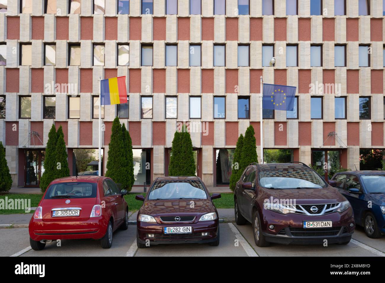 Bukarest, Rumänien. Mai 2024. Europäische und rumänische Flaggen vor einem Palast im Stadtzentrum Stockfoto