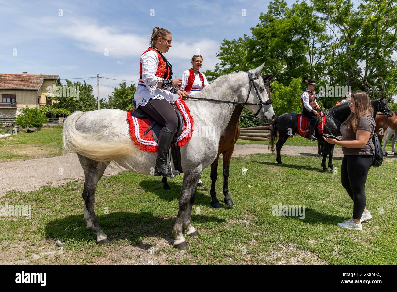 Osijek, Kroatien. Mai 2024. Frauen sitzen auf einem Pferderücken an der Prozession während der Veranstaltung „Straßen unseres Dorfes“, die vom Pferdezuchtverband „Baranjac“ am 26. Mai 2026 im Dorf Jagodnjak in der Nähe von Osijek in Kroatien organisiert wurde. Foto: Davor Javorovic/PIXSELL Credit: Pixsell/Alamy Live News Stockfoto