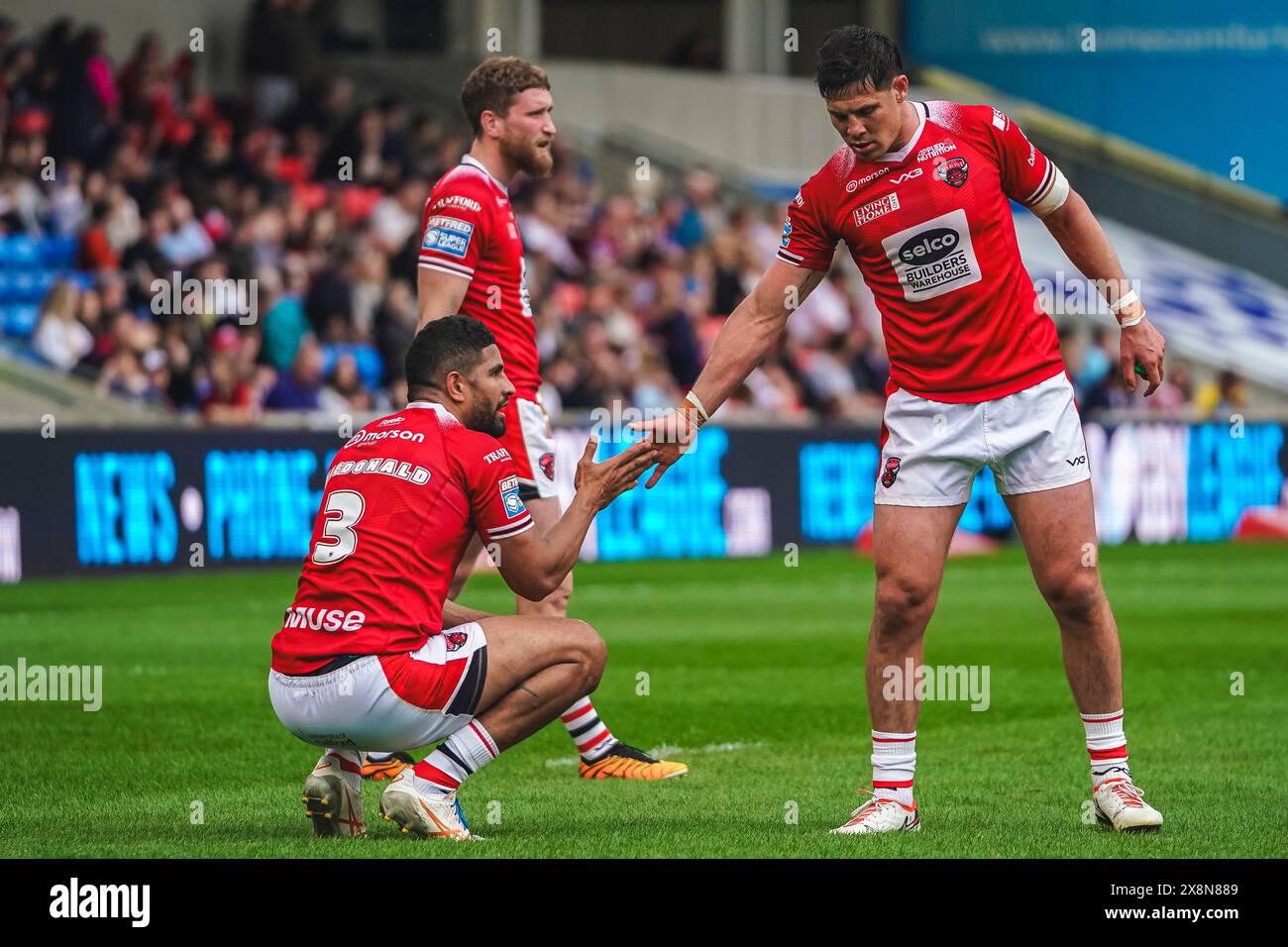 Salford, Manchester, Großbritannien. Mai 2024. Super League Rugby: Salford Red Devils gegen Wigan Warriors im Salford Community Stadium. SAM STONE und NENE MACDONALD teilen sich einen High Five nach nen's Versuch zu treffen. James Giblin/Alamy Live News. Stockfoto