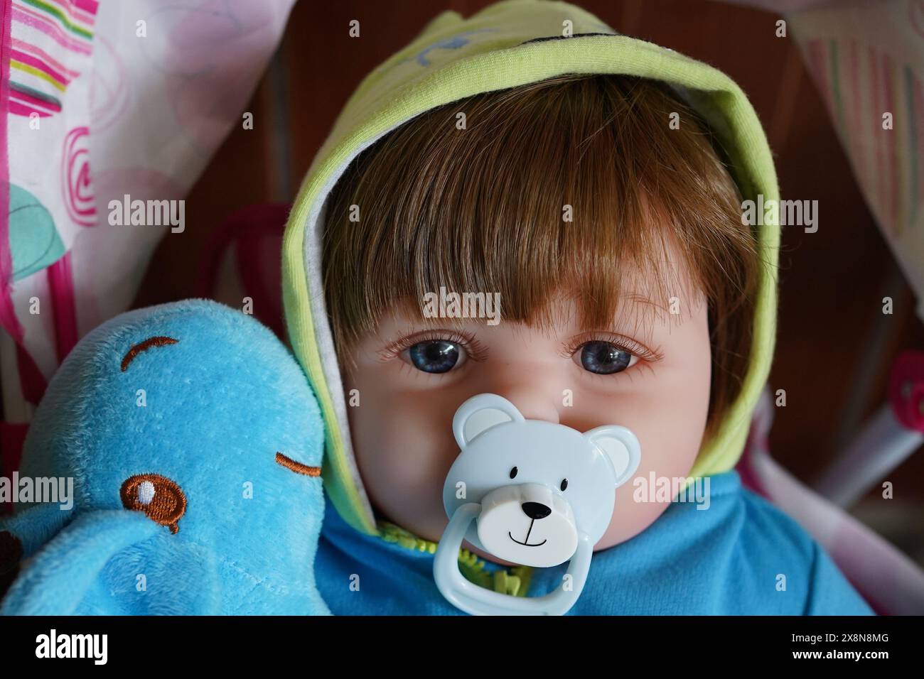 Die Babypuppe sieht aus wie ein echtes Kind mit einem Babyschnuller. Gut für Baby Magazin. Stockfoto