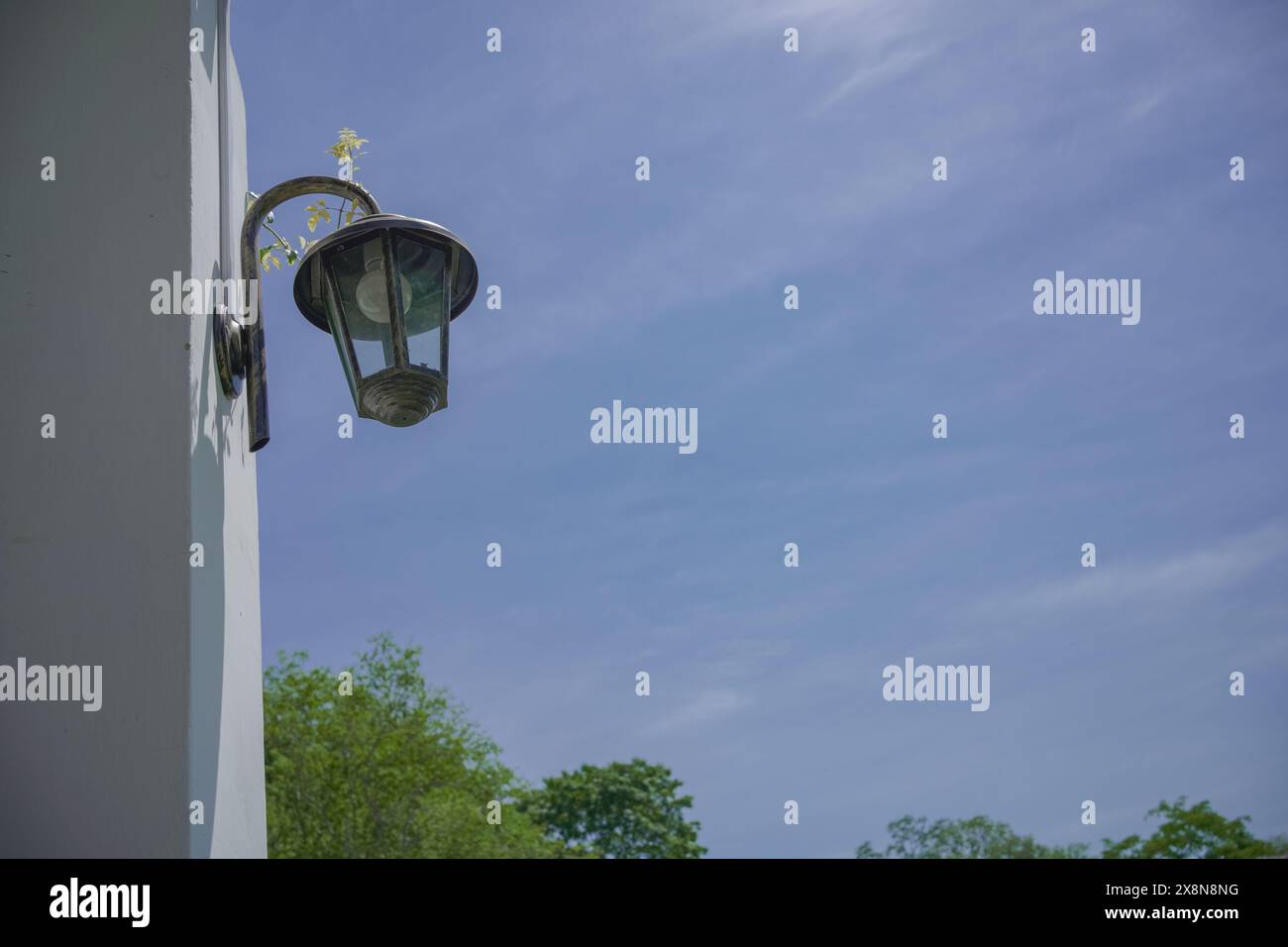 Klassische Lampe an der Hauswand. Außenleuchte mit blauem Himmel Hintergrund. Stockfoto