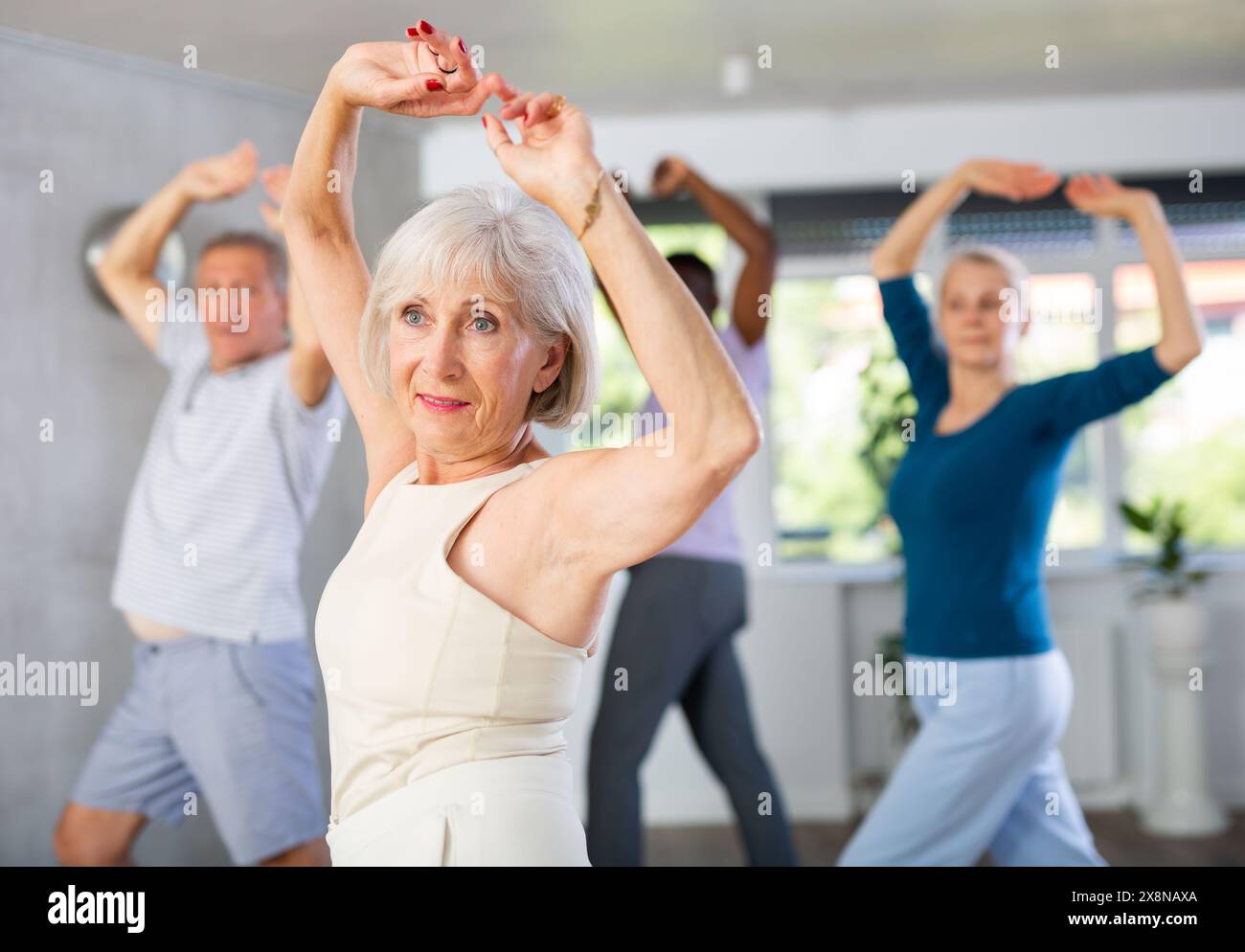 Senior Lady genießt Flamenco während des Gruppentanzkurses Stockfoto