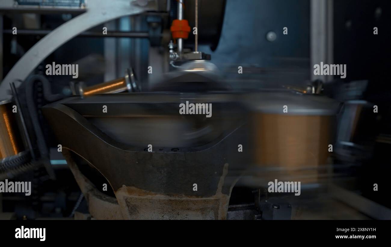 Rotierende Spulen mit Draht. Kreativ. Schnell rotierende Spulen mit Kupferdraht in metallurgischen Unternehmen. Automatisierte Kupferdrahtwickelmaschine Stockfoto