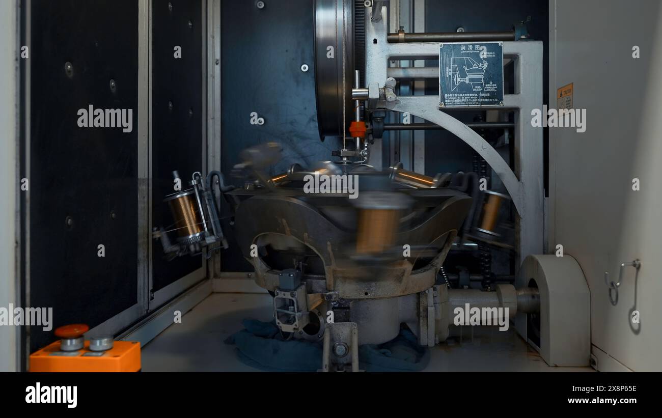 Rotierende Maschine mit Kupferdrahtwicklung. Kreativ. Automatisierte Maschine zum Wickeln von Kupferdraht auf Spulen. Drehen mehrerer Spulen zum Einwickeln von Drähten Stockfoto
