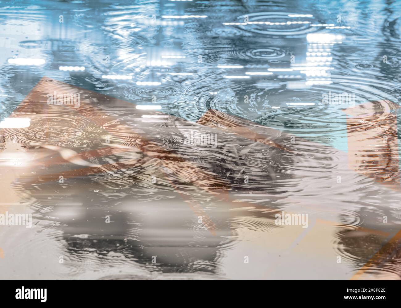 Doppelbelichtung städtischer abstrakter Hintergrund. Regentropfen auf der Wasseroberfläche mit Stadtreflexionen. Stockfoto
